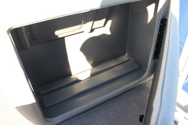 2025 Sun Tracker Fishin' Barge 22 DLX storage compartment, open and empty.