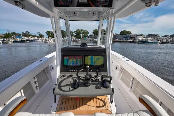 Manufacturer Provided Image: Helm of 2026 Jupiter 340LS boat with advanced navigation systems, docked at marina.