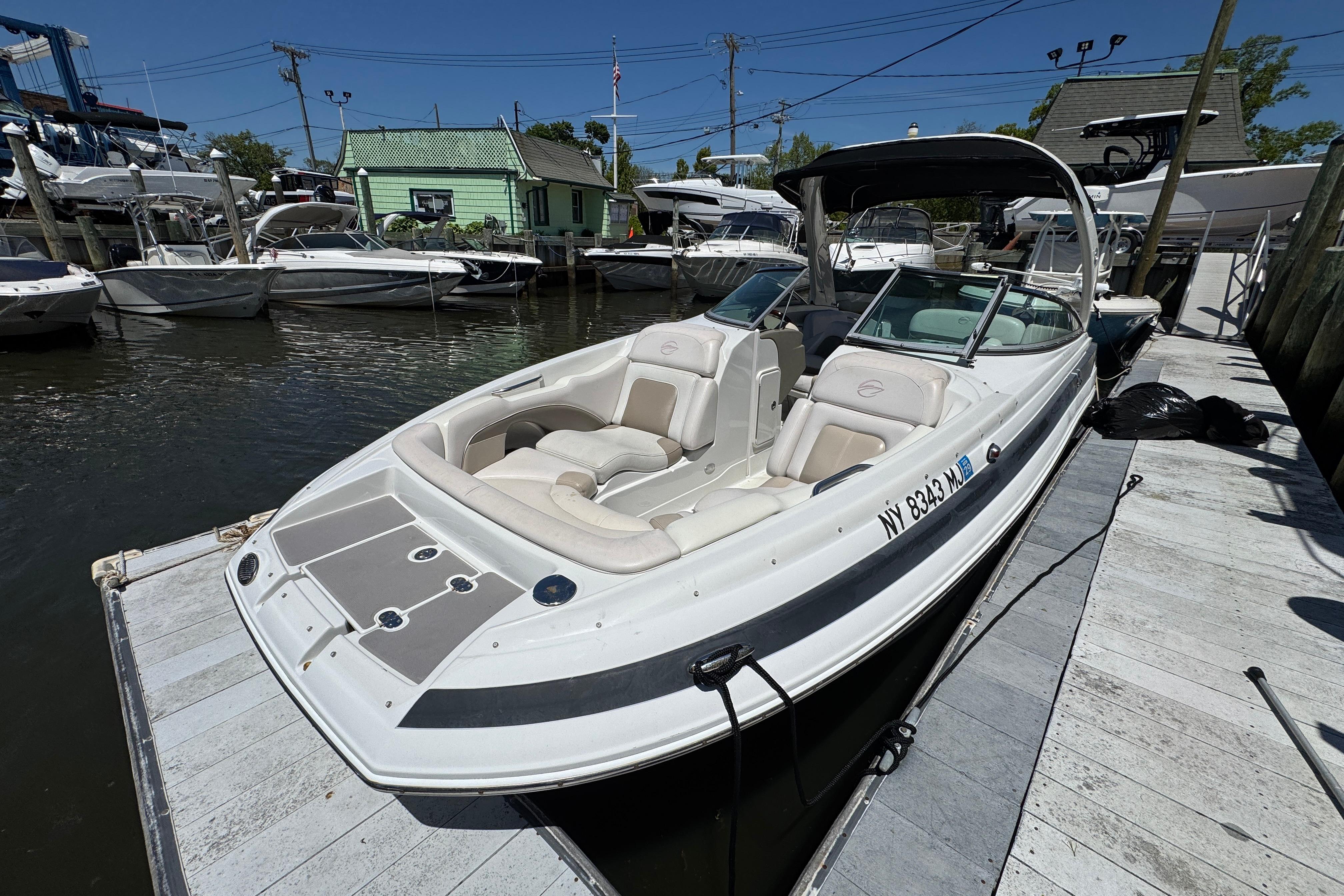 2013 Crownline Eclipse E6 XS boat docked at marina, featuring spacious seating and sleek design.