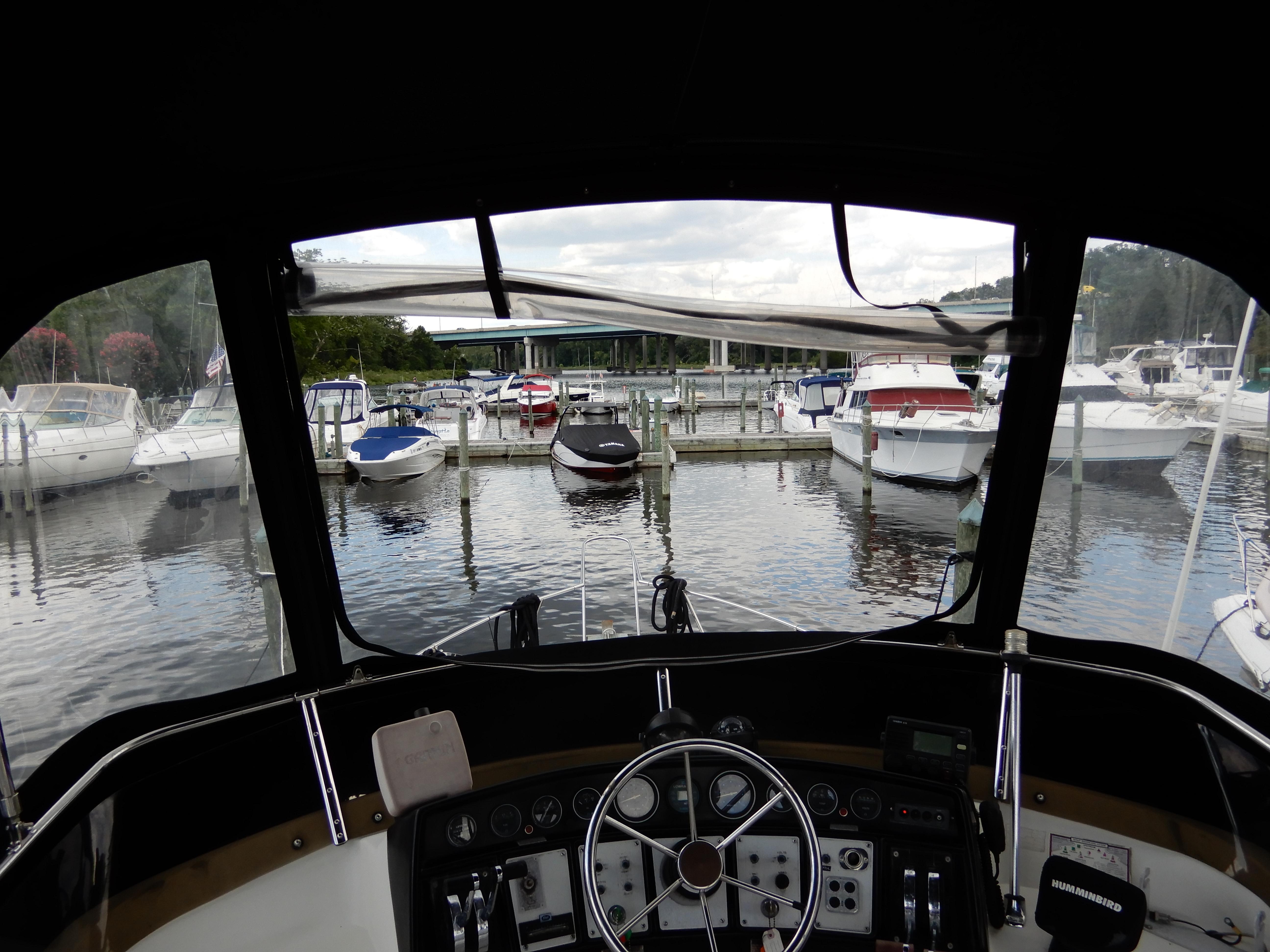 View from 1987 Carver 28 Mariner/Voyager helm, overlooking marina with docked boats.