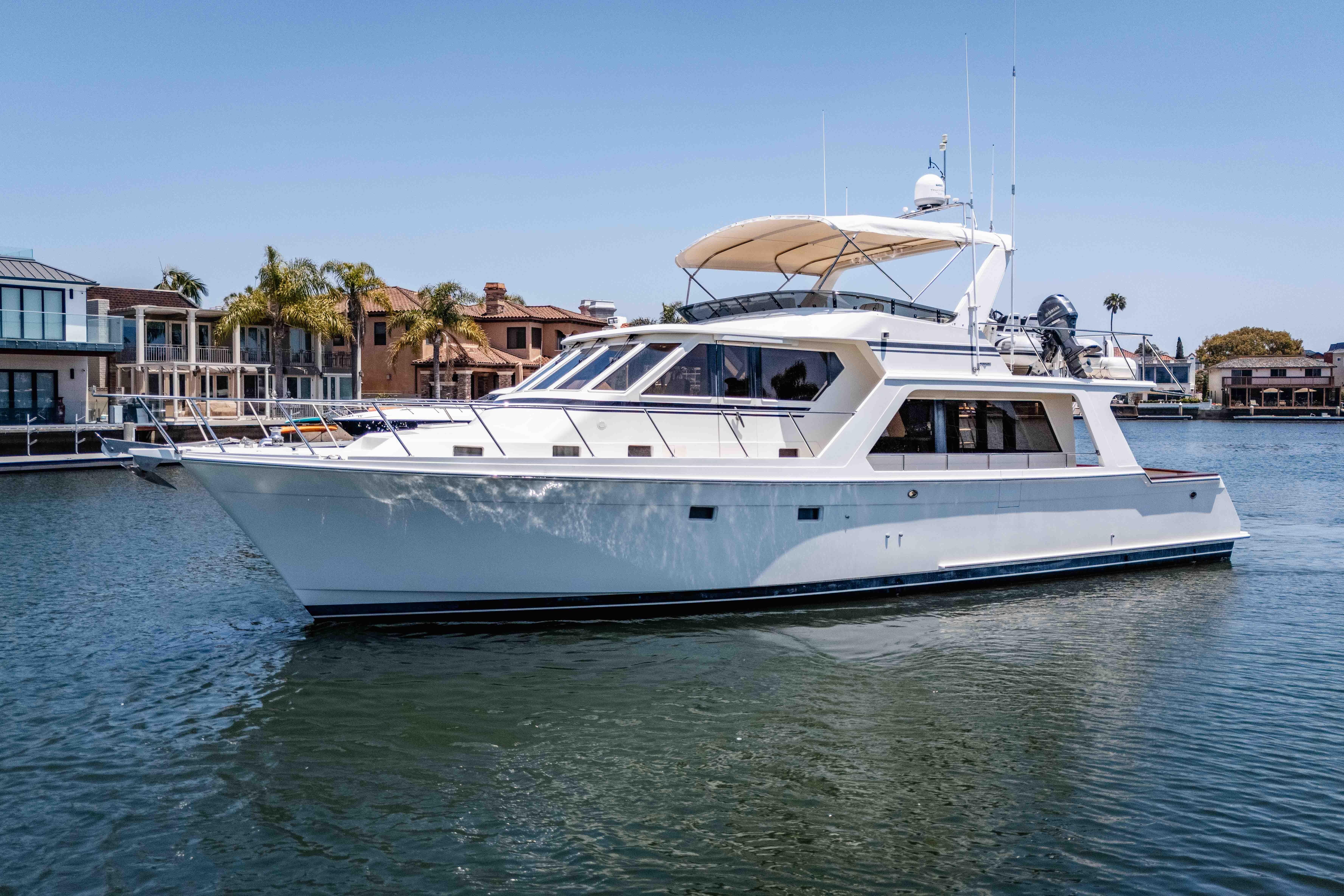 2005 Offshore Yachts 54 Pilothouse cruising in a serene waterfront setting.