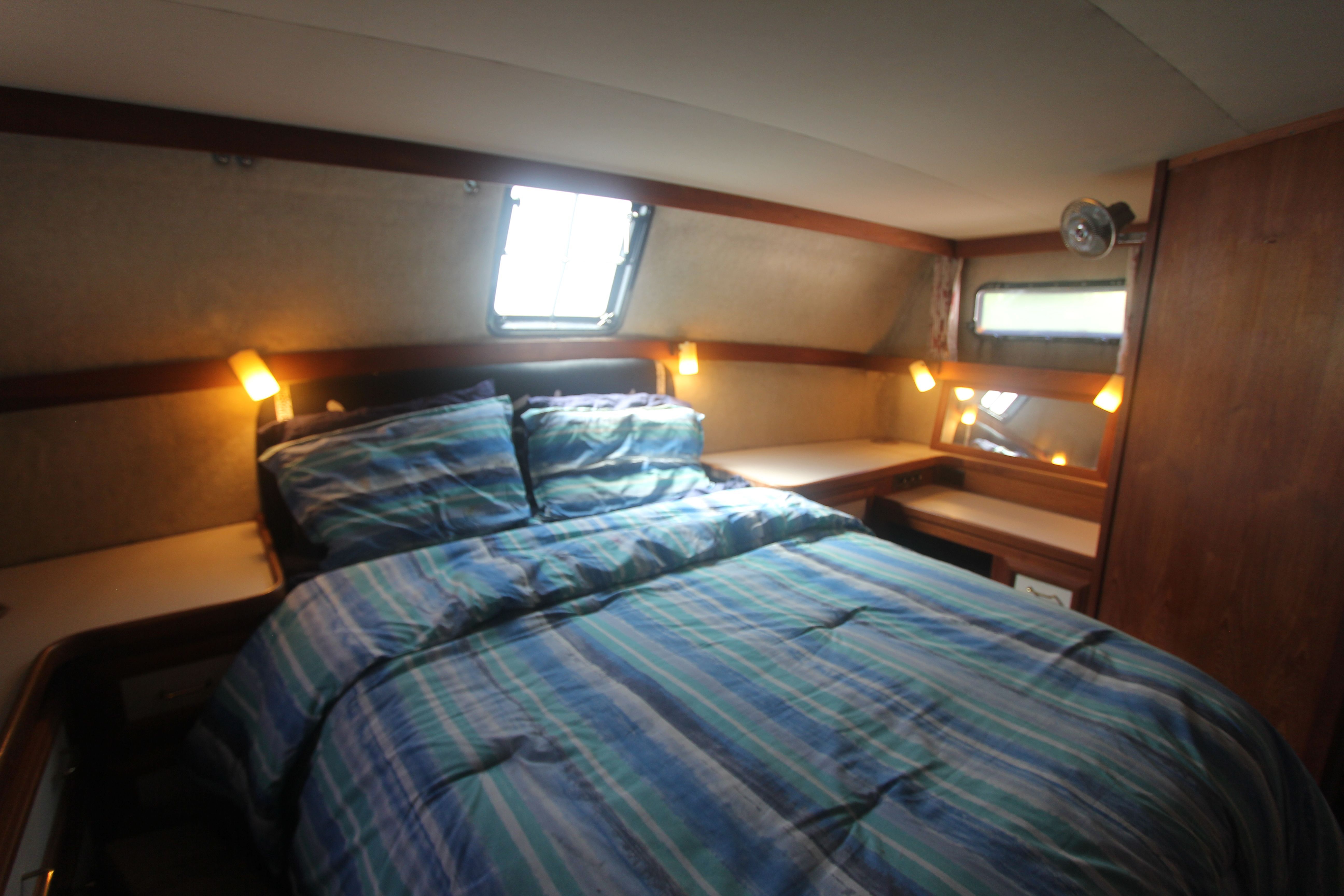 The image shows a cozy cabin with a double bed and striped bedding.