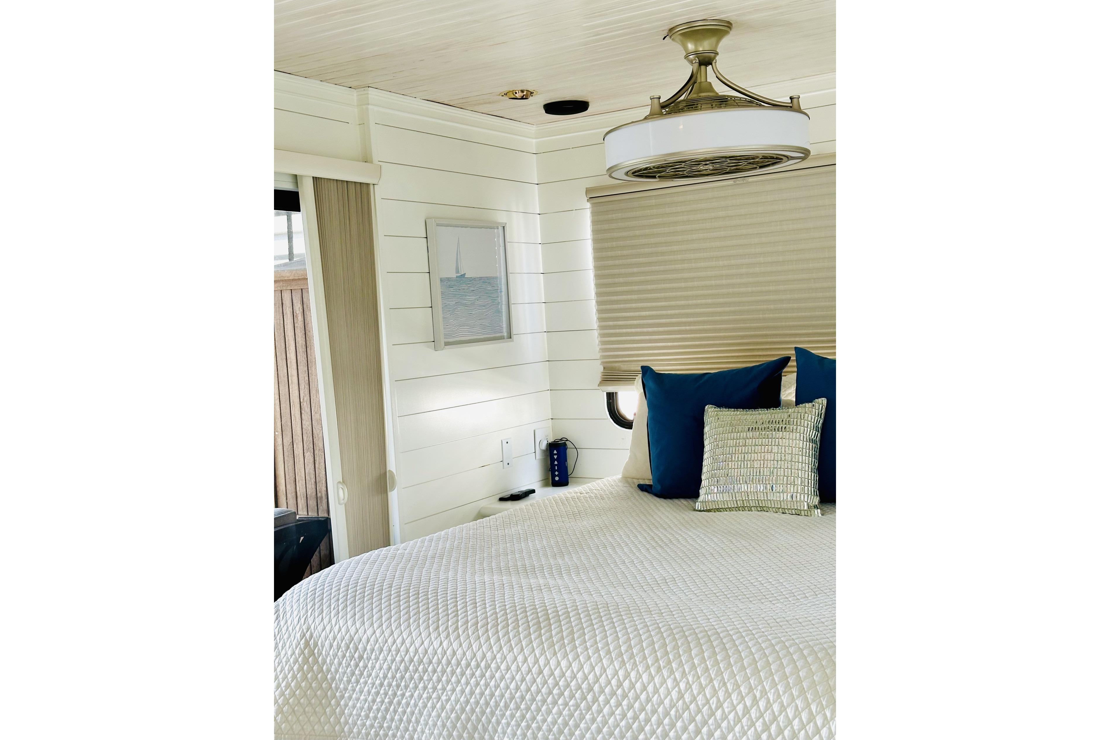 Cozy bedroom interior in 1992 Sumerset 66 houseboat with modern decor and nautical theme.