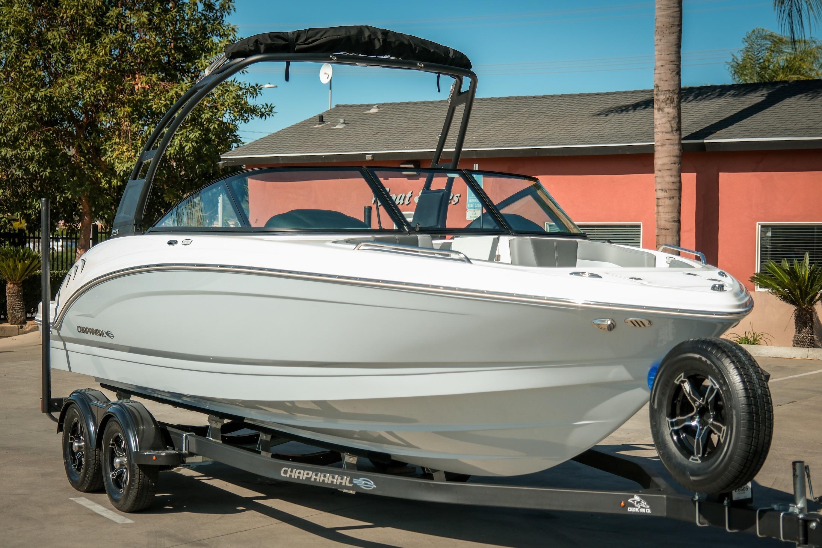 2026 Chaparral 23 SSi boat on trailer, parked outdoors, showcasing sleek design.