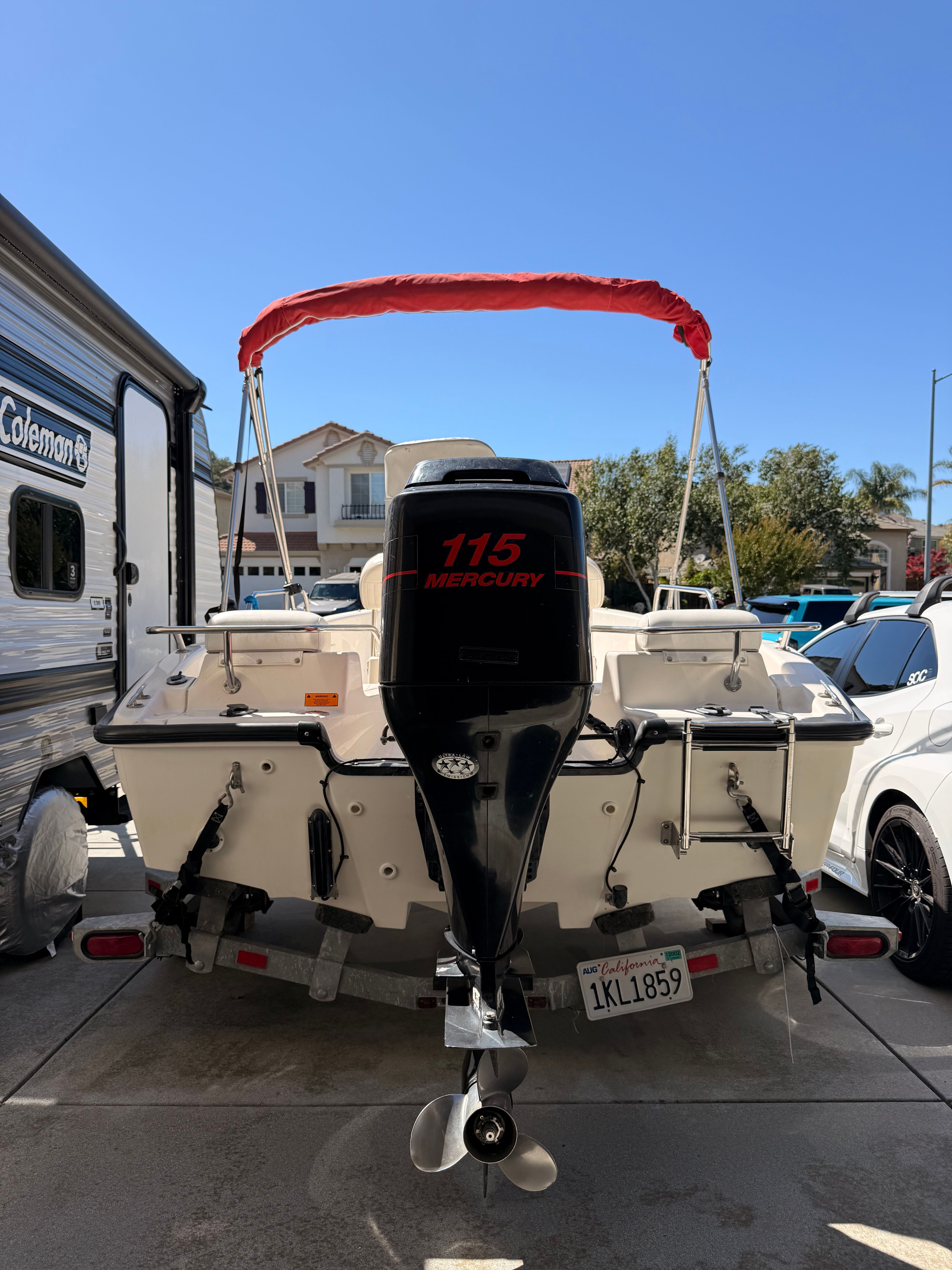A 2002 Boston Whaler 160 Dauntless with a 115 Mercury outboard motor, parked on a trailer.