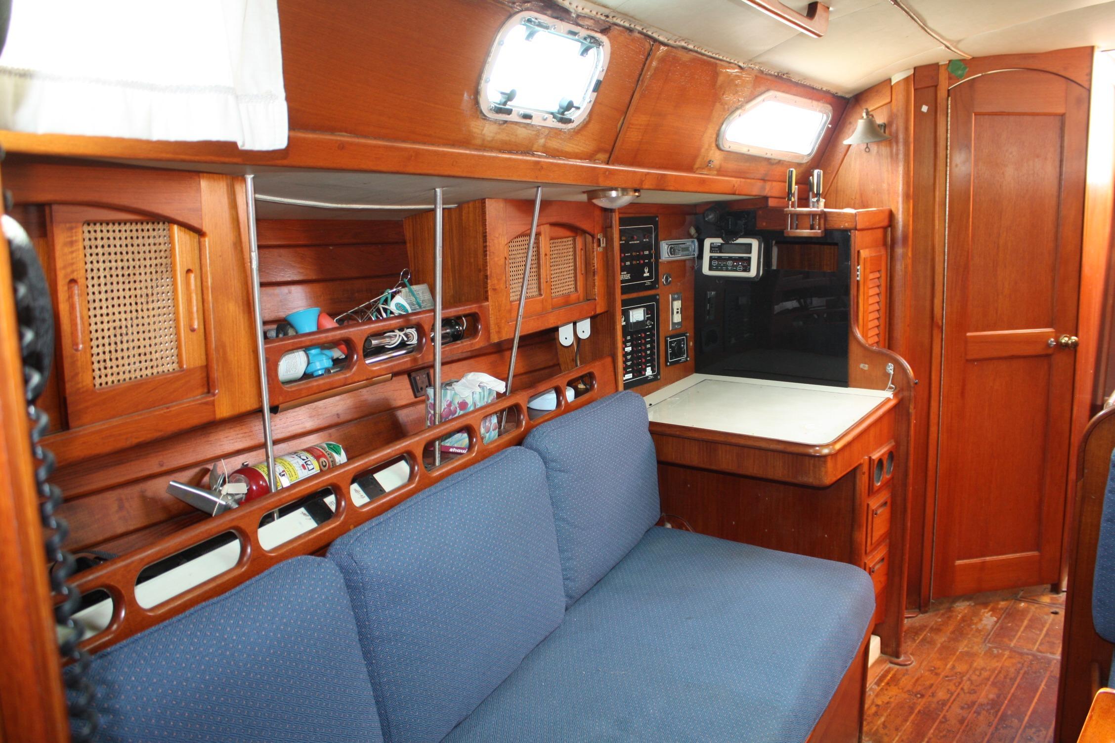 Interior of 1987 Ericson 38-200 sailboat with wooden cabinetry and blue seating.