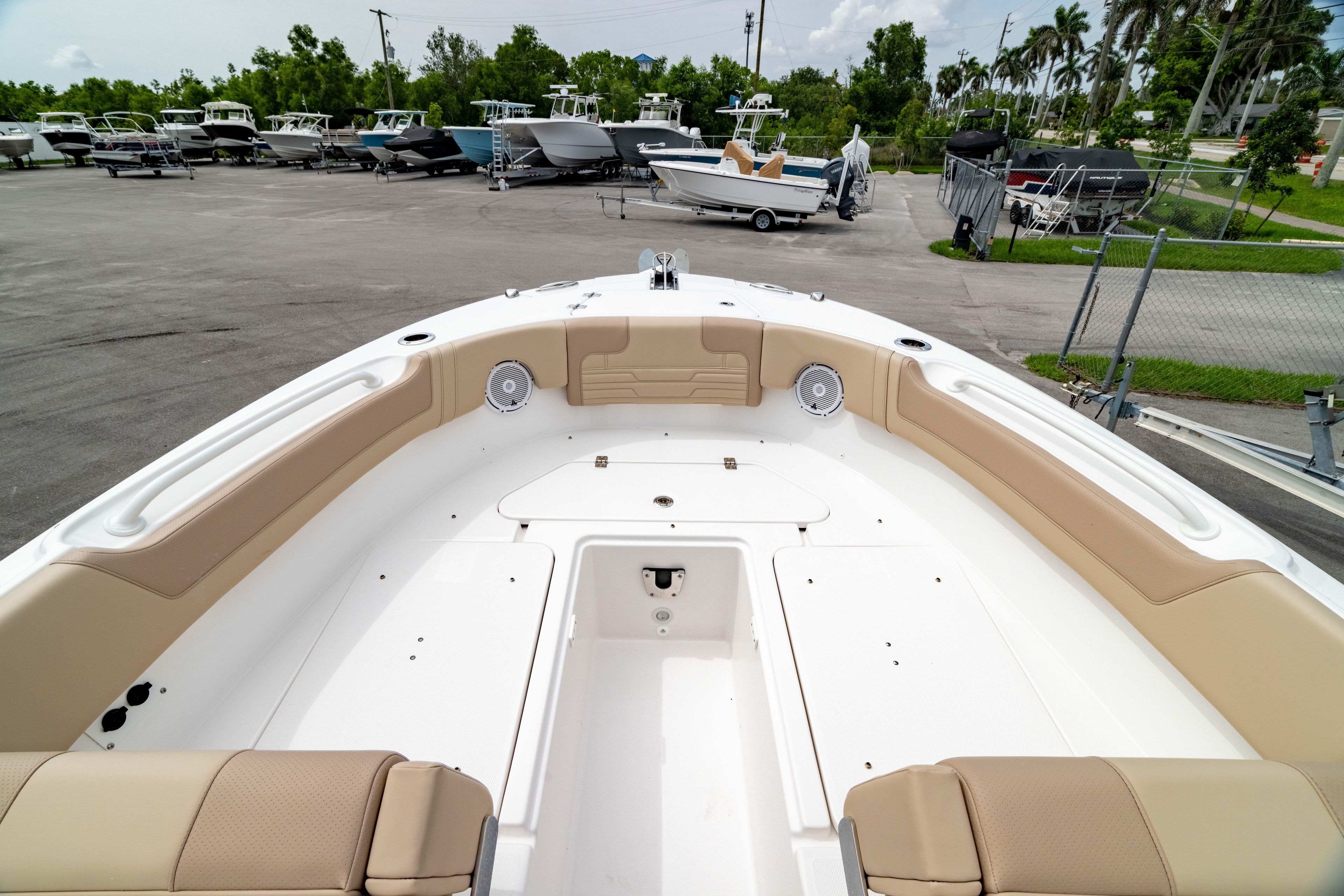 2026 Edgewater 248 CX boat interior with beige seating, parked in a marina.