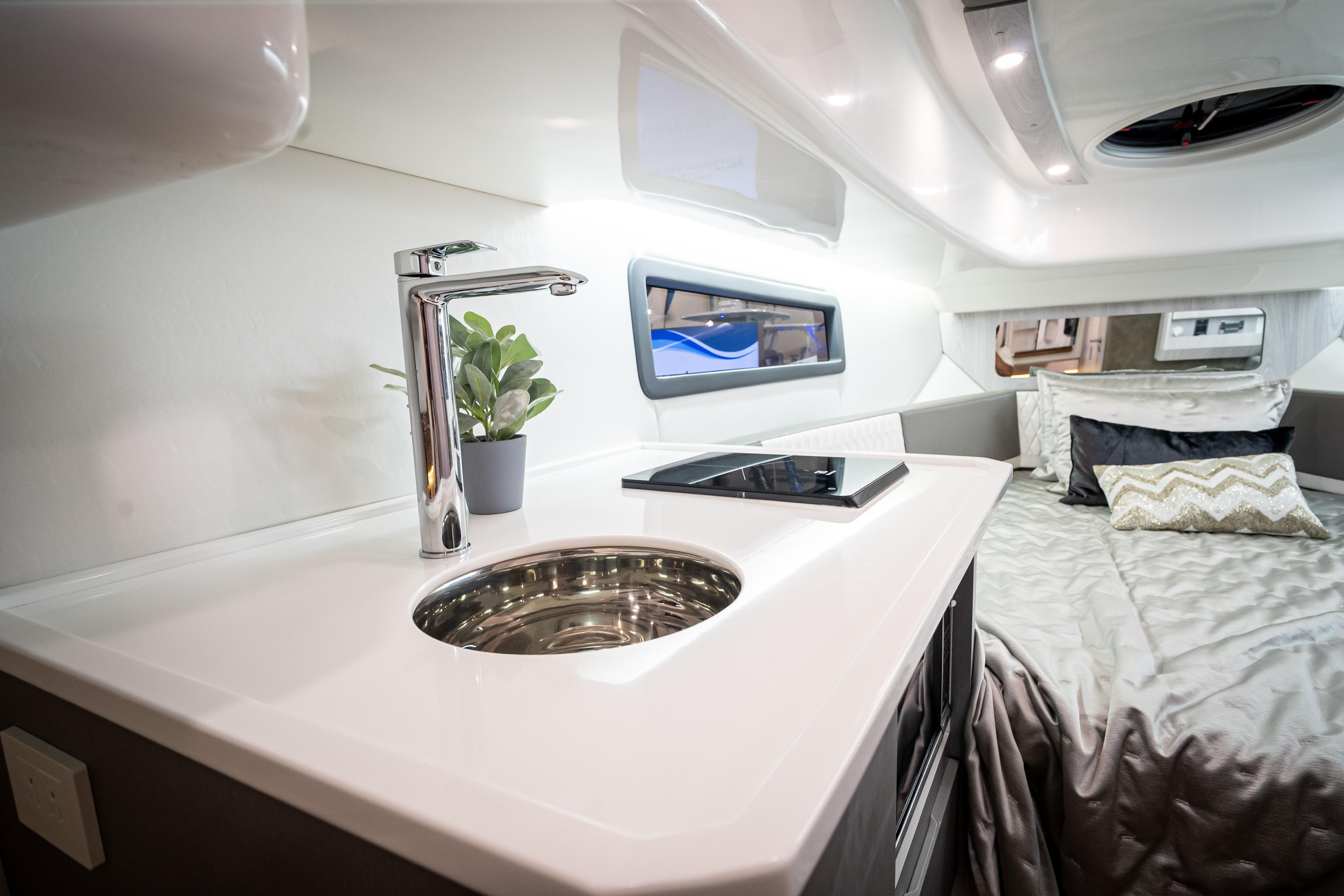 Luxurious interior of 2026 Hanover 347 with modern kitchenette and cozy sleeping area.
