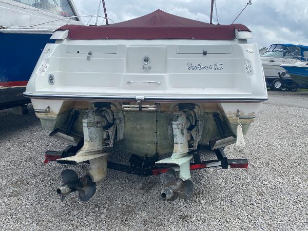 1992 Regal Ventura boat with dual outboard motors on a gravel lot.