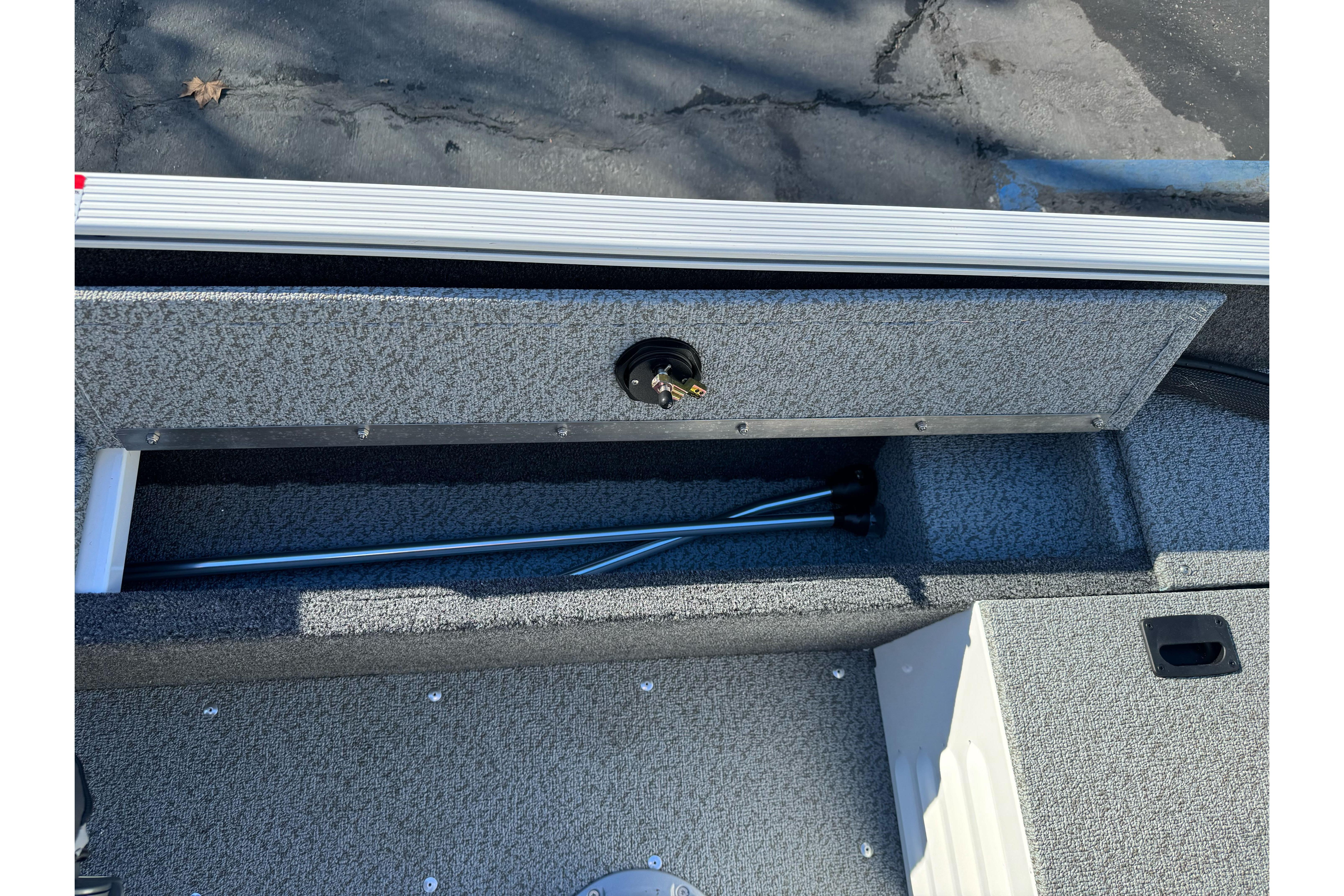 2026 Lund 1650 Angler SS boat storage compartment with fishing rod holder.
