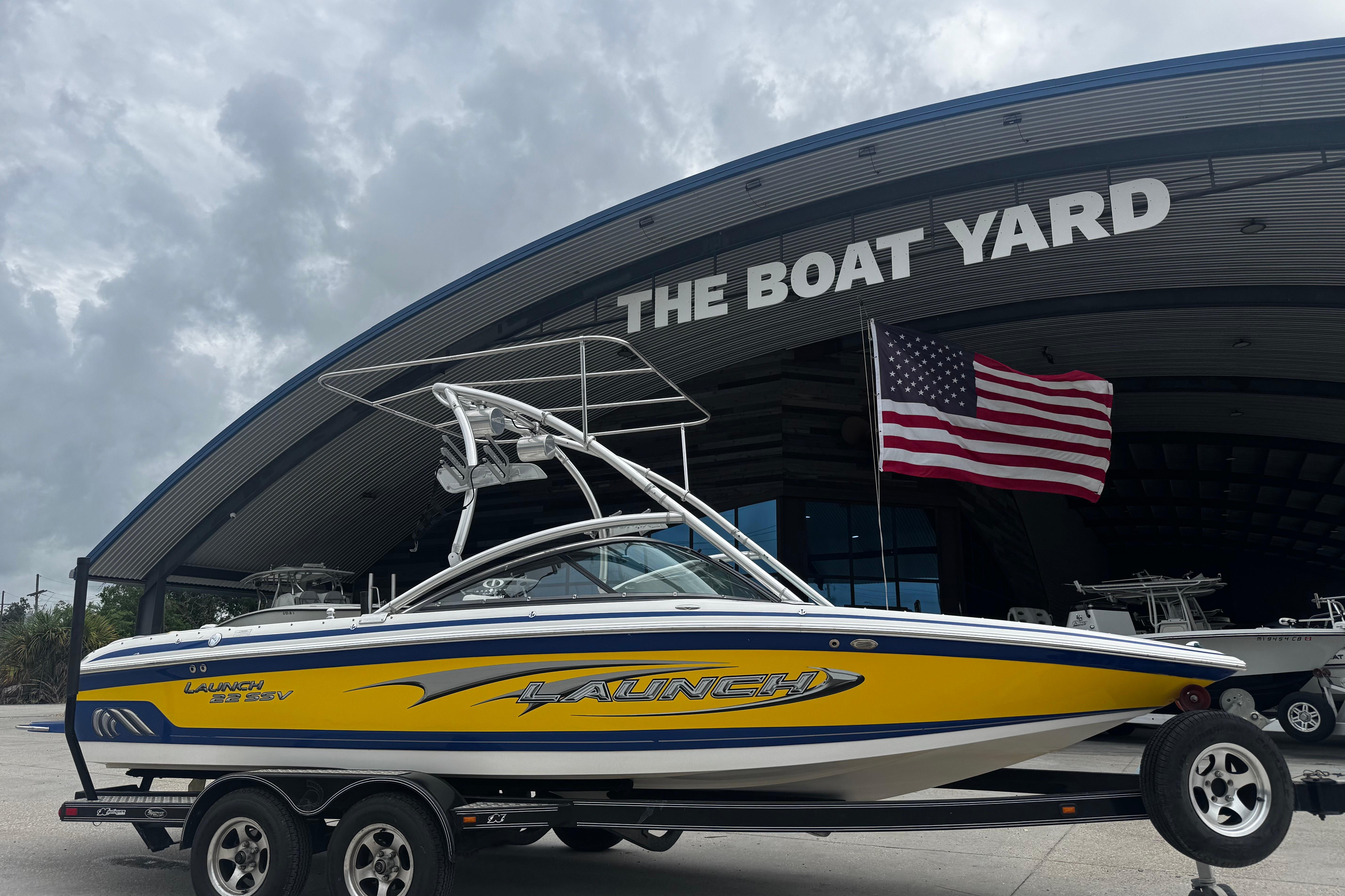 2006 Supra Launch 22 SSV boat on trailer at The Boat Yard, American flag displayed.