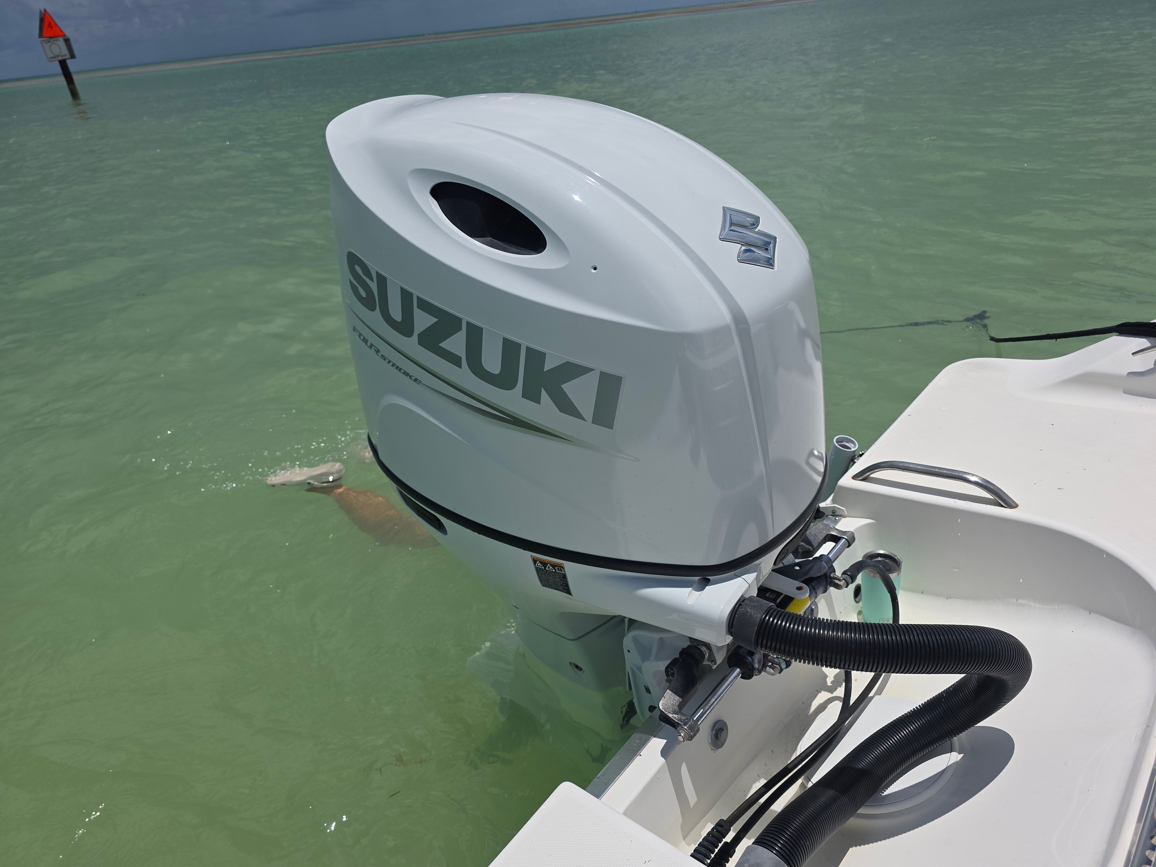 Suzuki outboard motor on Wellcraft Sportsman 2001 in clear water.