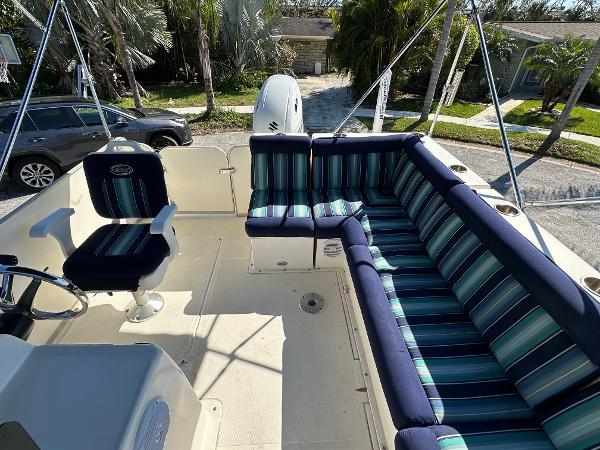 2020 Beachcat 20 boat with striped seating, parked near palm trees.