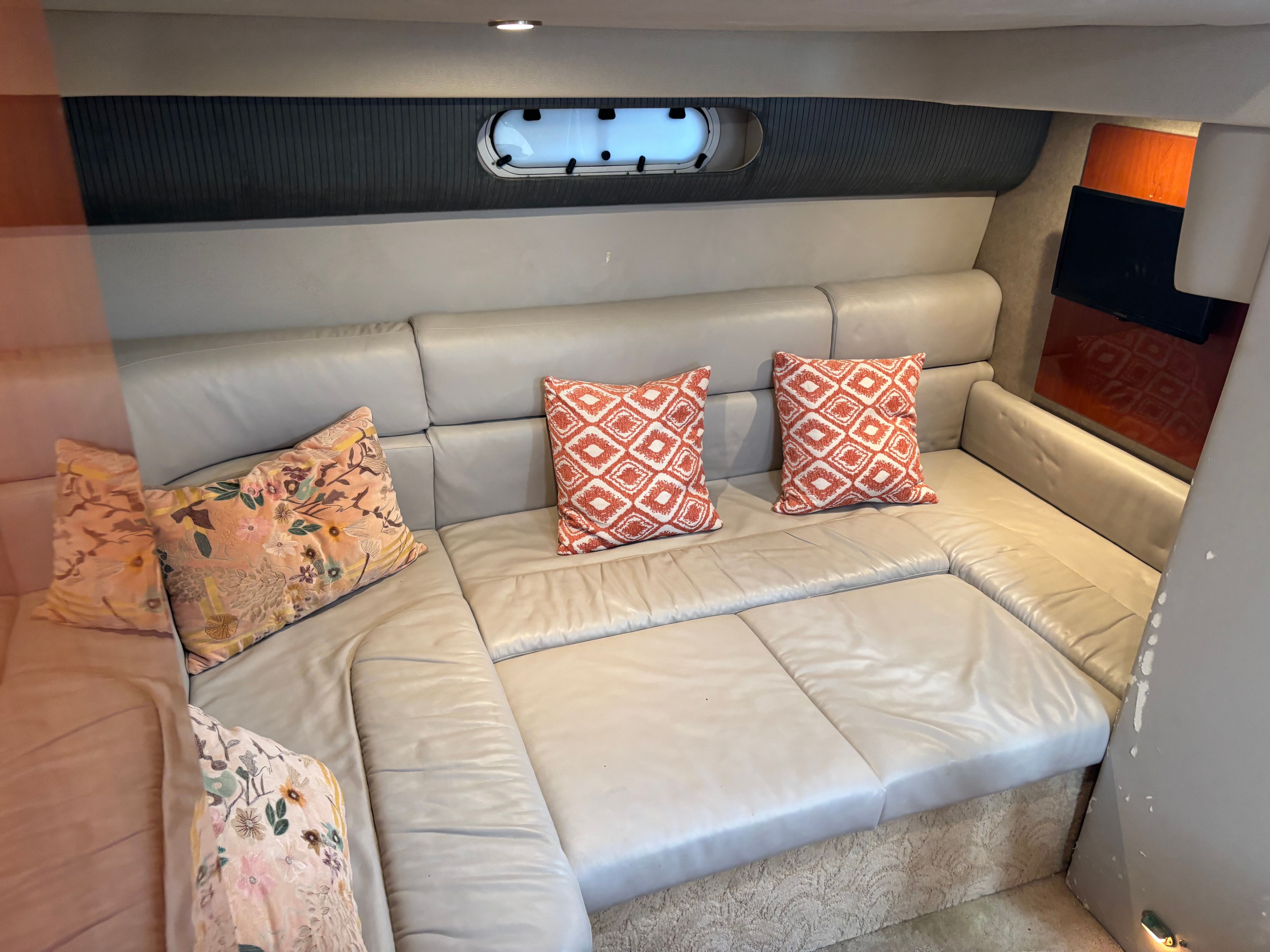Interior of a 2005 Formula 40 Performance Cruiser with beige leather sofa and decorative pillows.