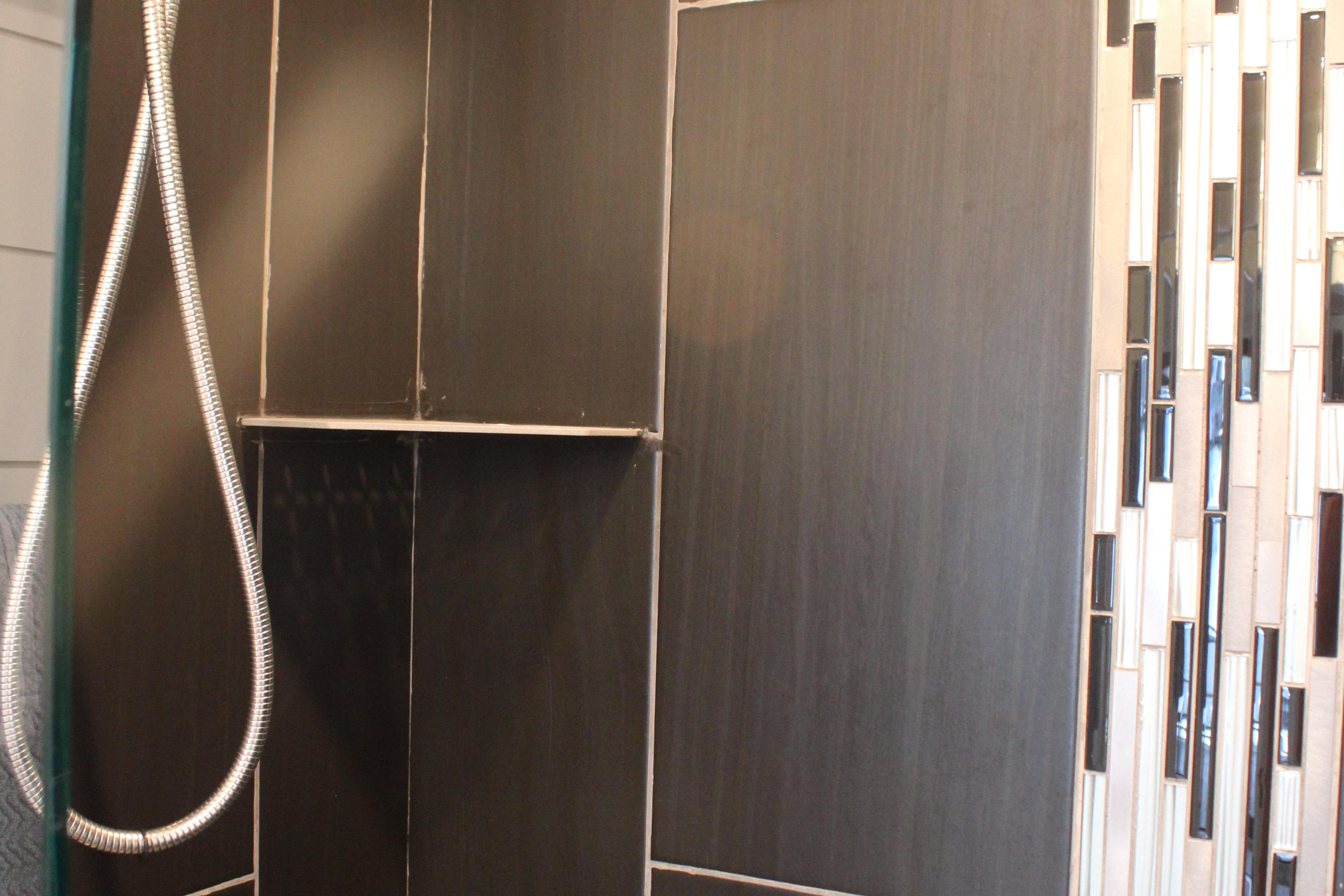 Shower area with modern dark tiles and mosaic accents, Sumerset 66, 1992 model.