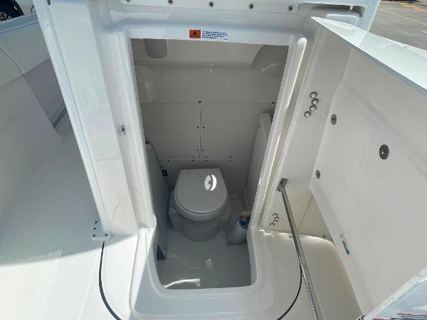 2023 Robalo R270 boat interior with compact marine toilet.
