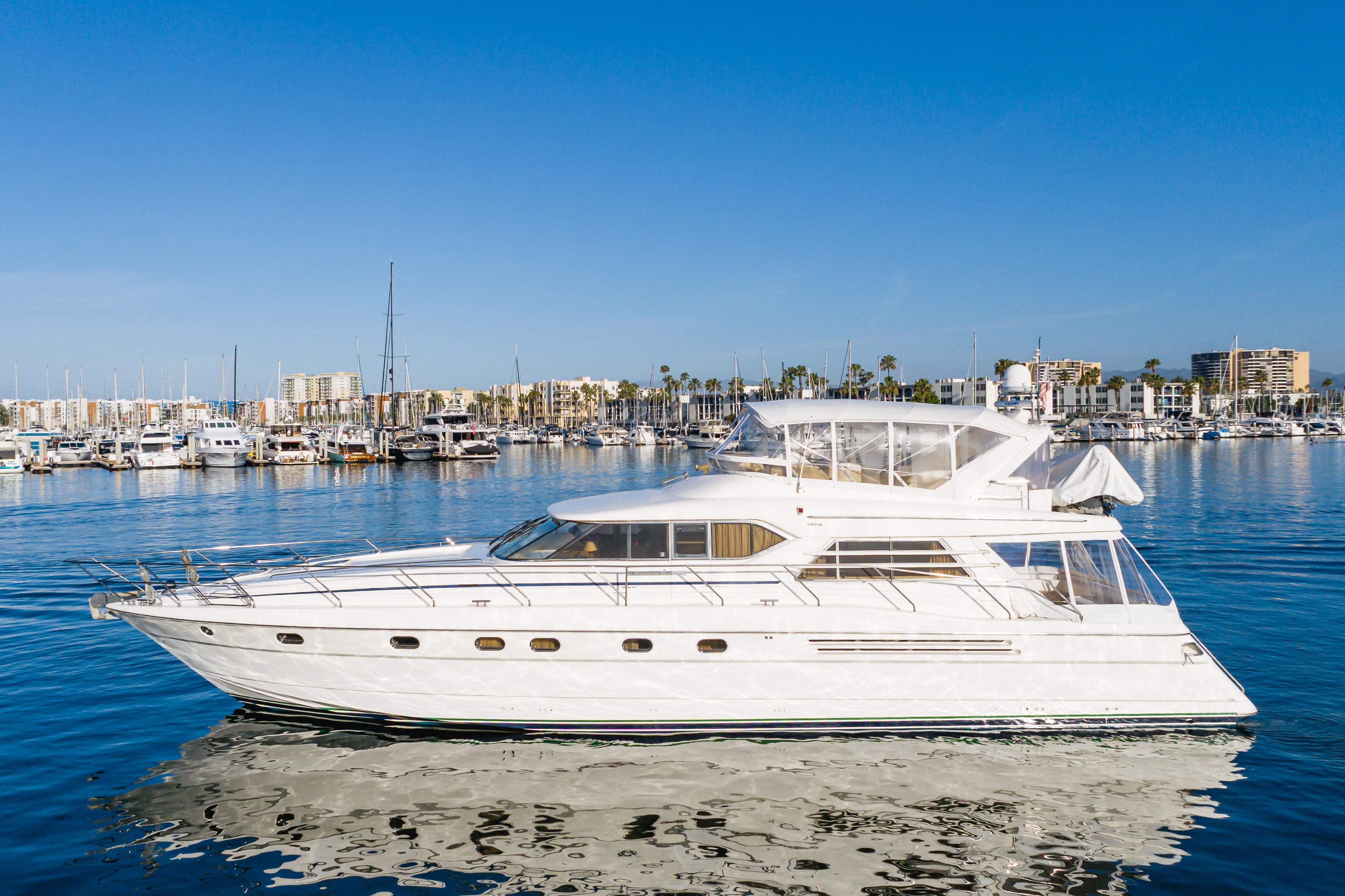 1997 Viking Sport Cruisers 66 Motor Yacht on calm water, marina background.