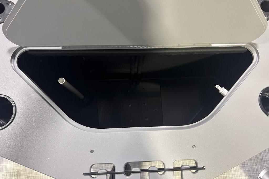 Open storage compartment on 2026 Dockside 22DF boat, featuring cup holders and utility fittings.