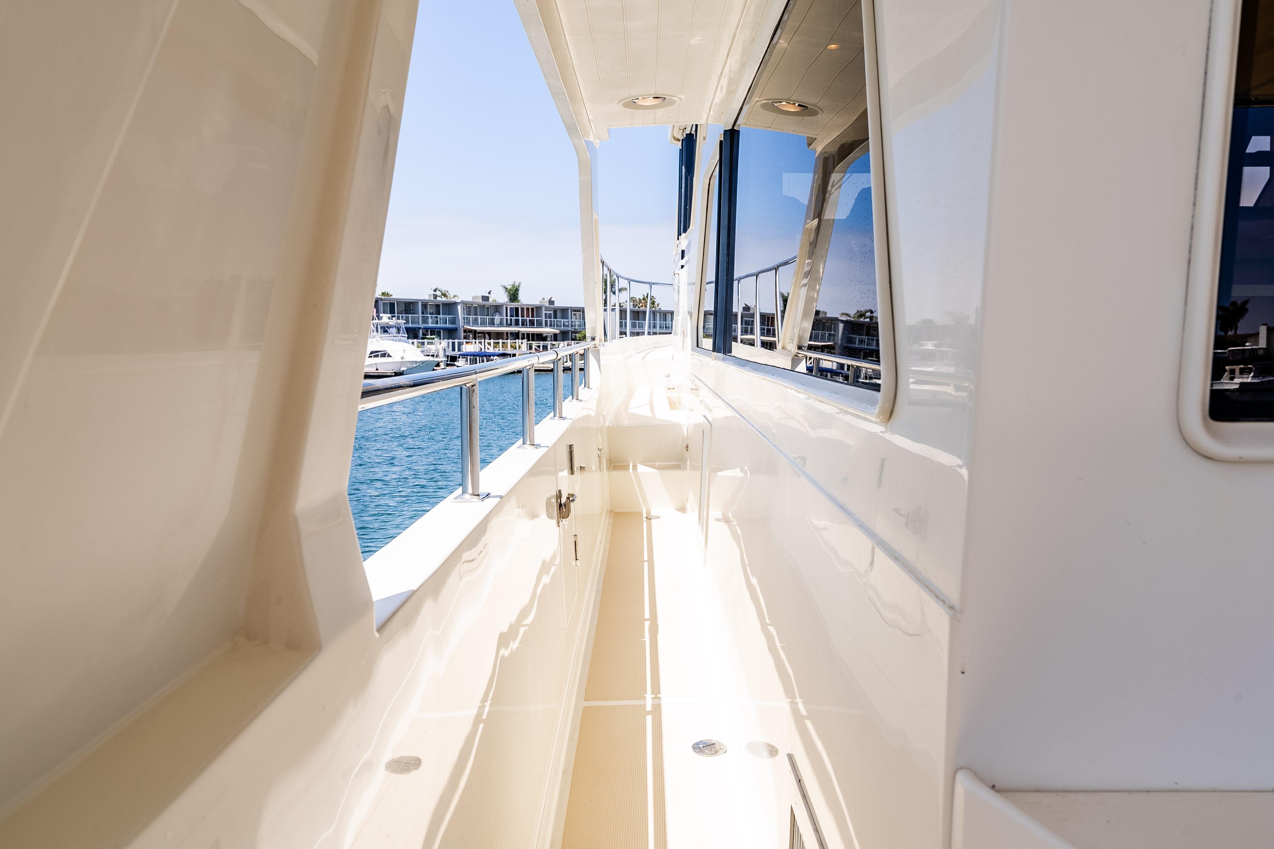 Side deck view of 2005 Offshore Yachts 54 Pilothouse, showcasing sleek design and waterfront.