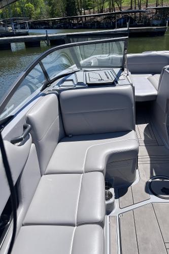 2024 Moomba Max boat interior with gray seating and open deck, docked by the water.