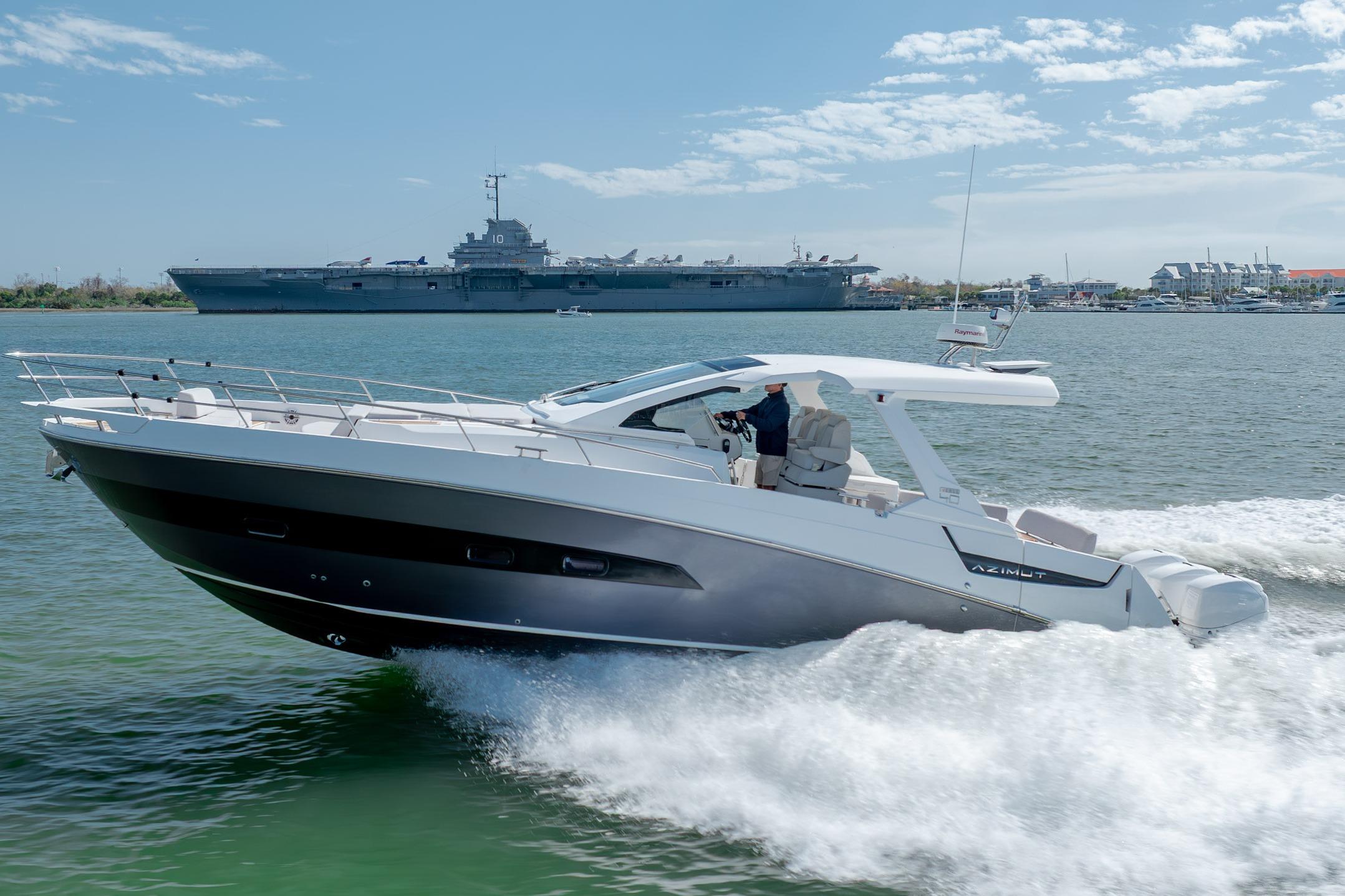 2019 Azimut Verve 40 yacht cruising on water with a large ship in the background.
