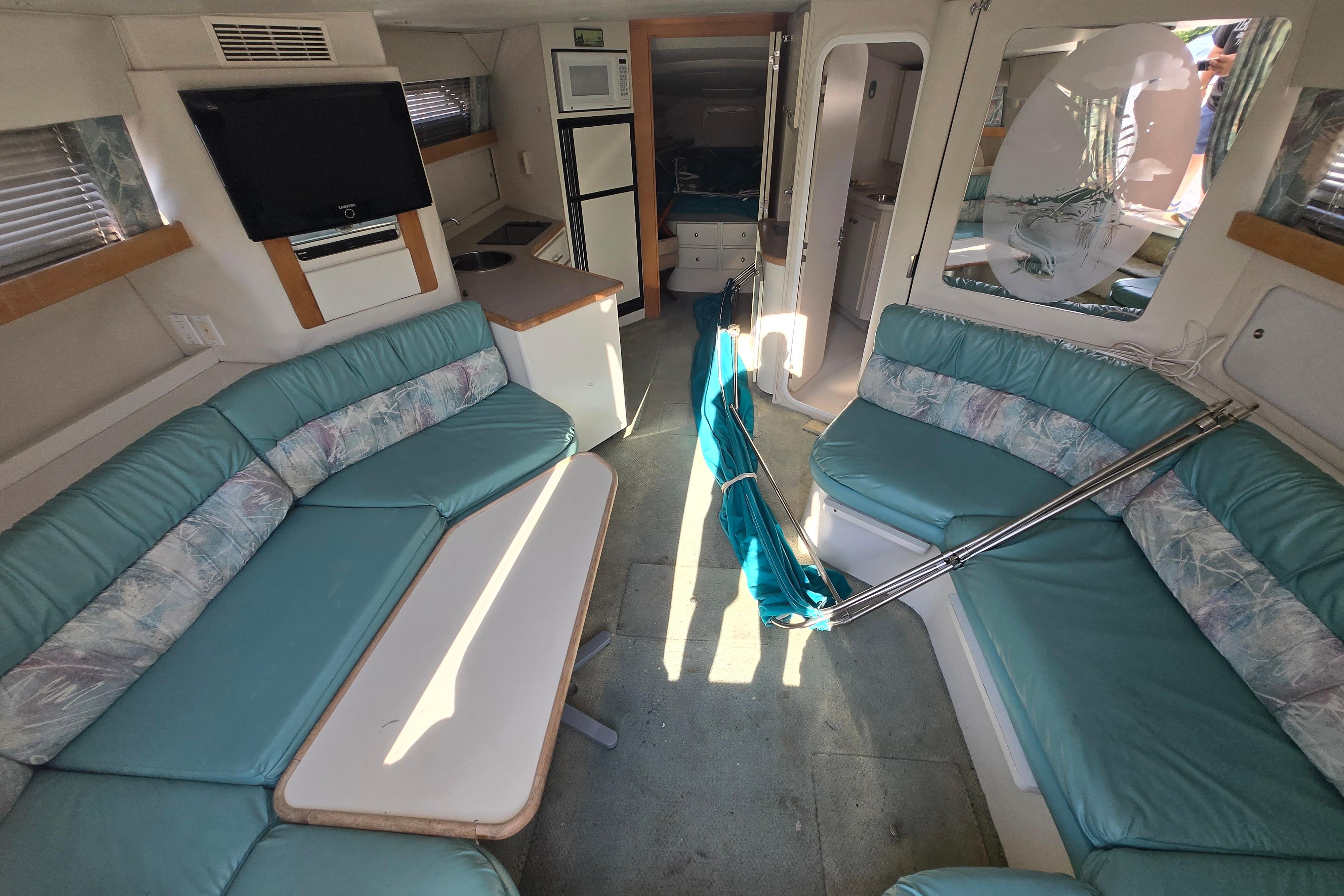 Interior of 1994 Carver 380 Santego yacht with teal seating and modern amenities.