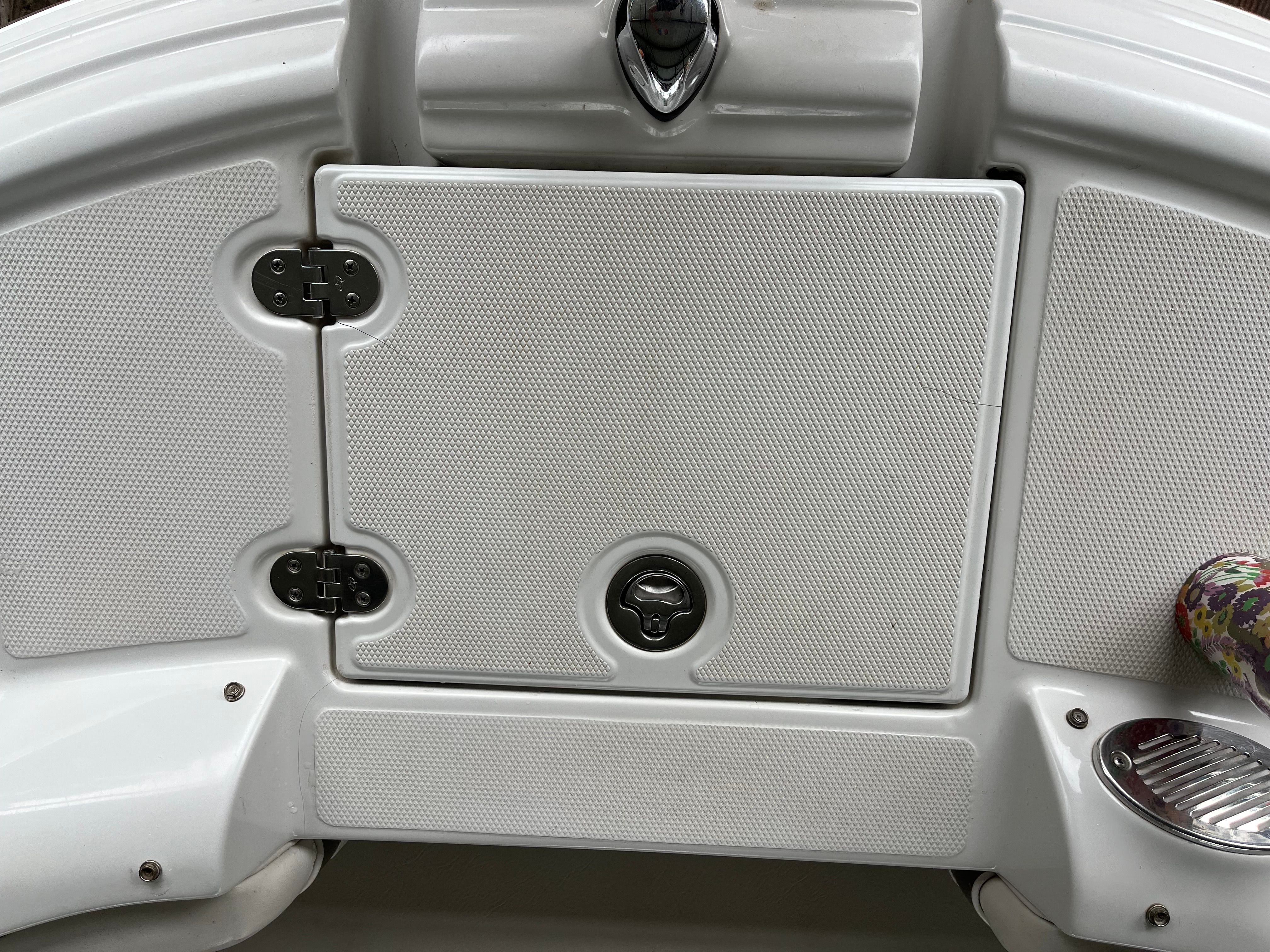 Close-up of a white boat hatch with handles and hinges.