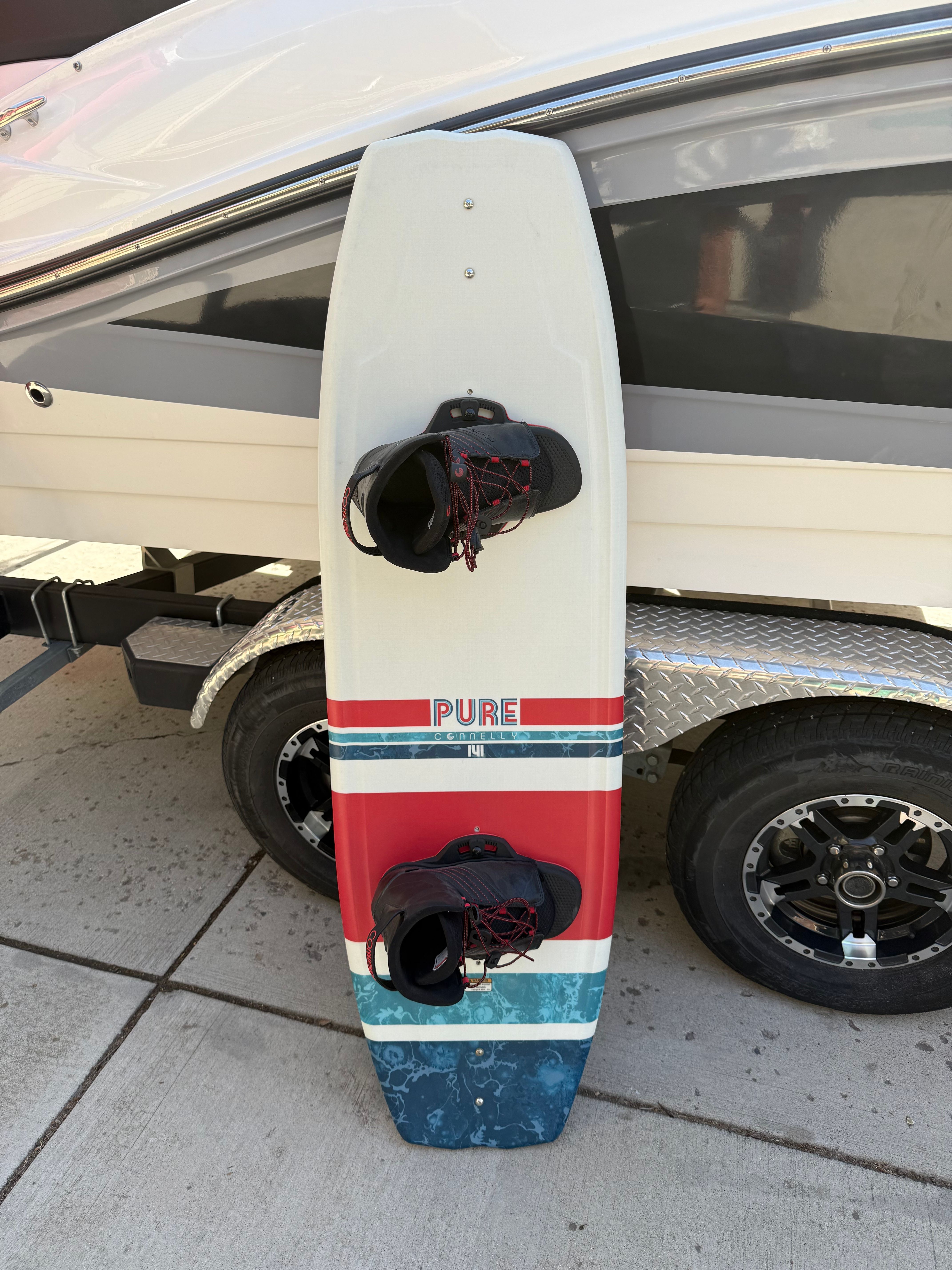 Wakeboard in front of a 2022 Sea Ray SPX 210 boat on trailer.