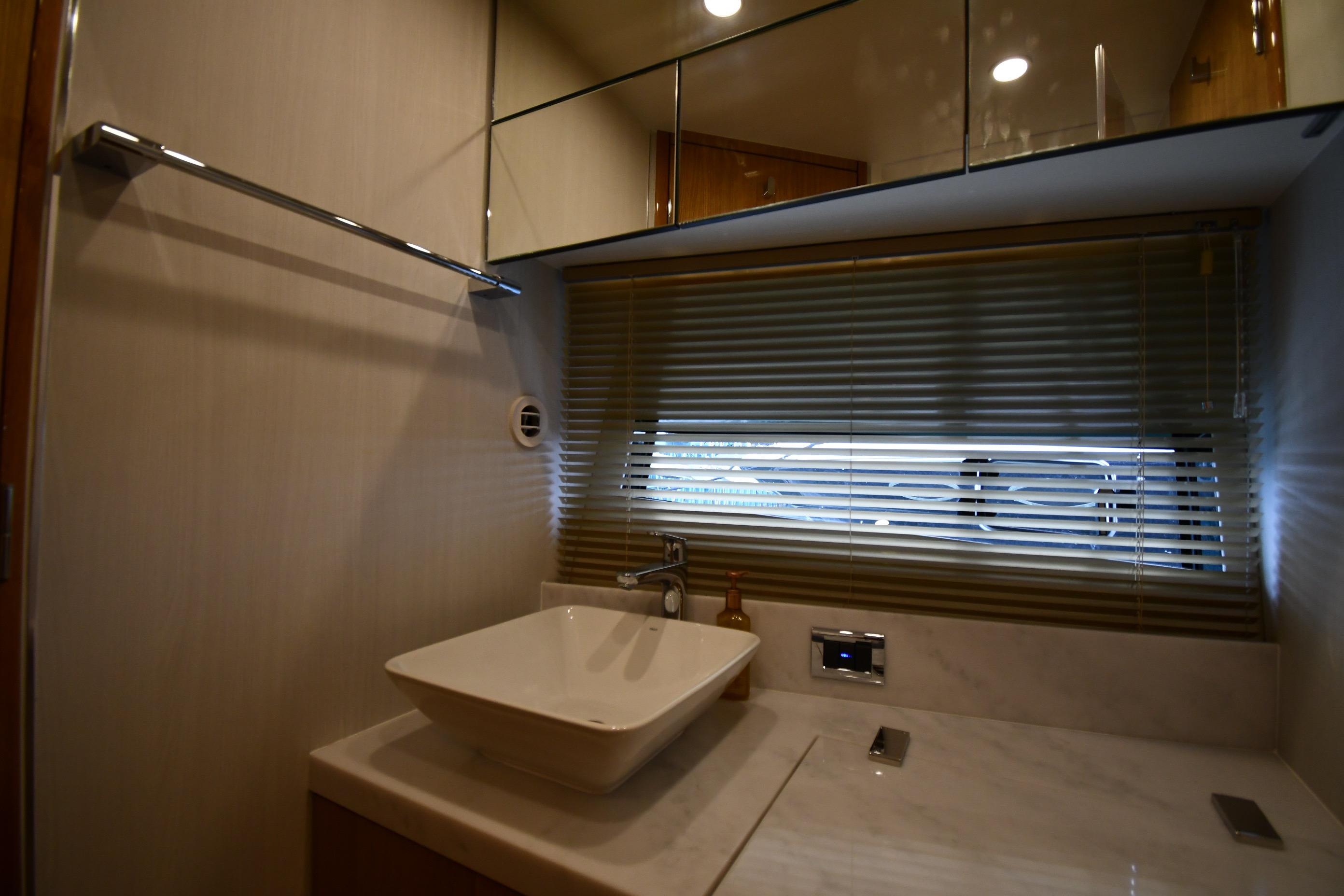 Luxurious bathroom interior of 2024 Fairline G50 Targa yacht with modern sink and blinds.