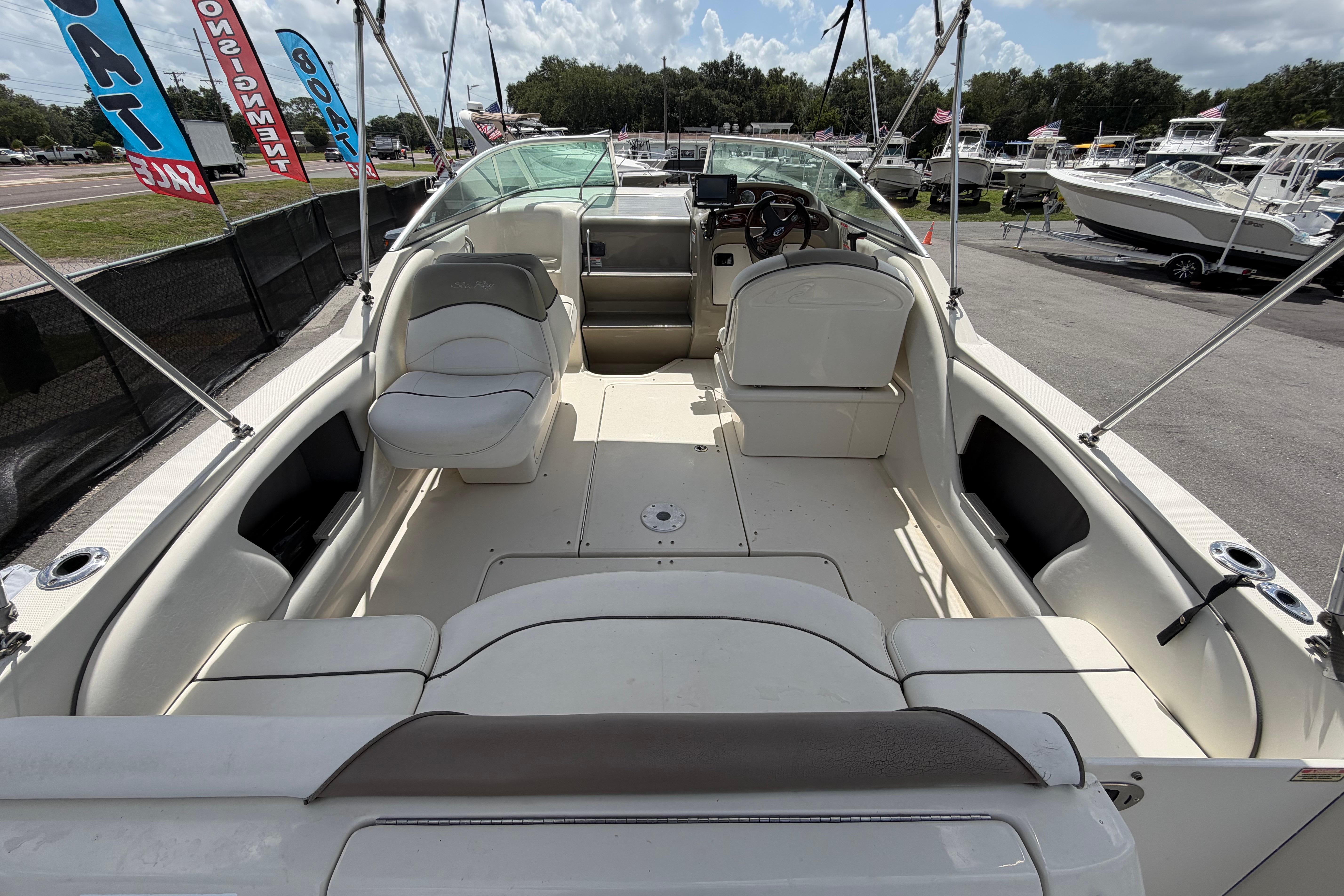 2006 Sea Ray 250 Amberjack boat interior with seating and steering wheel, displayed outdoors.