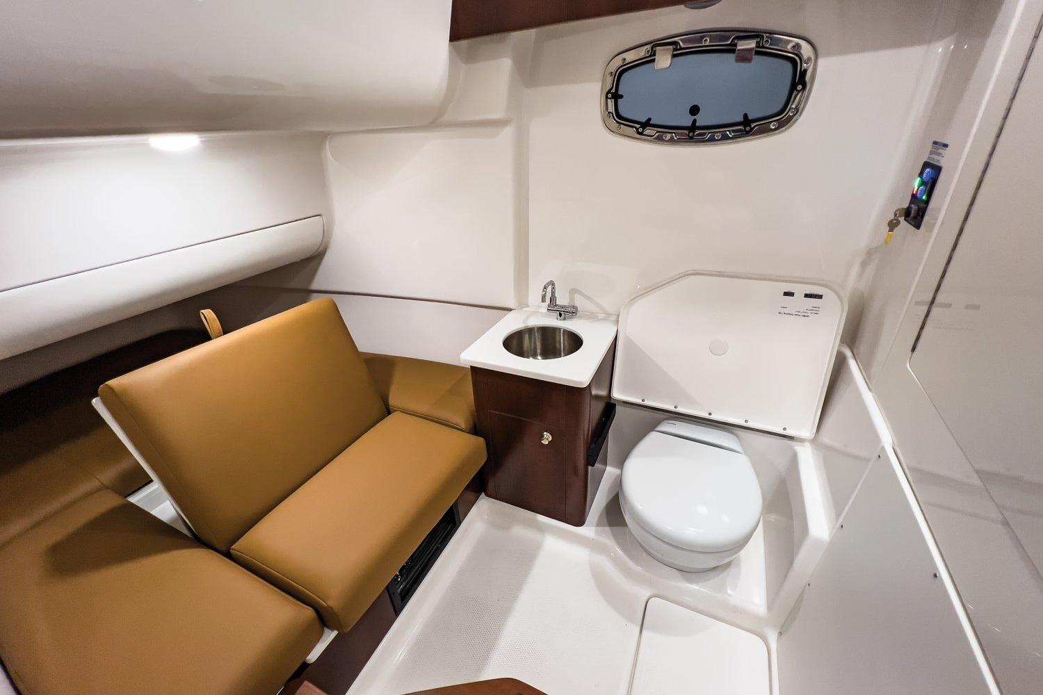 Manufacturer Provided Image: 2026 Robalo R360 Center Console cabin with seating, sink, and toilet.