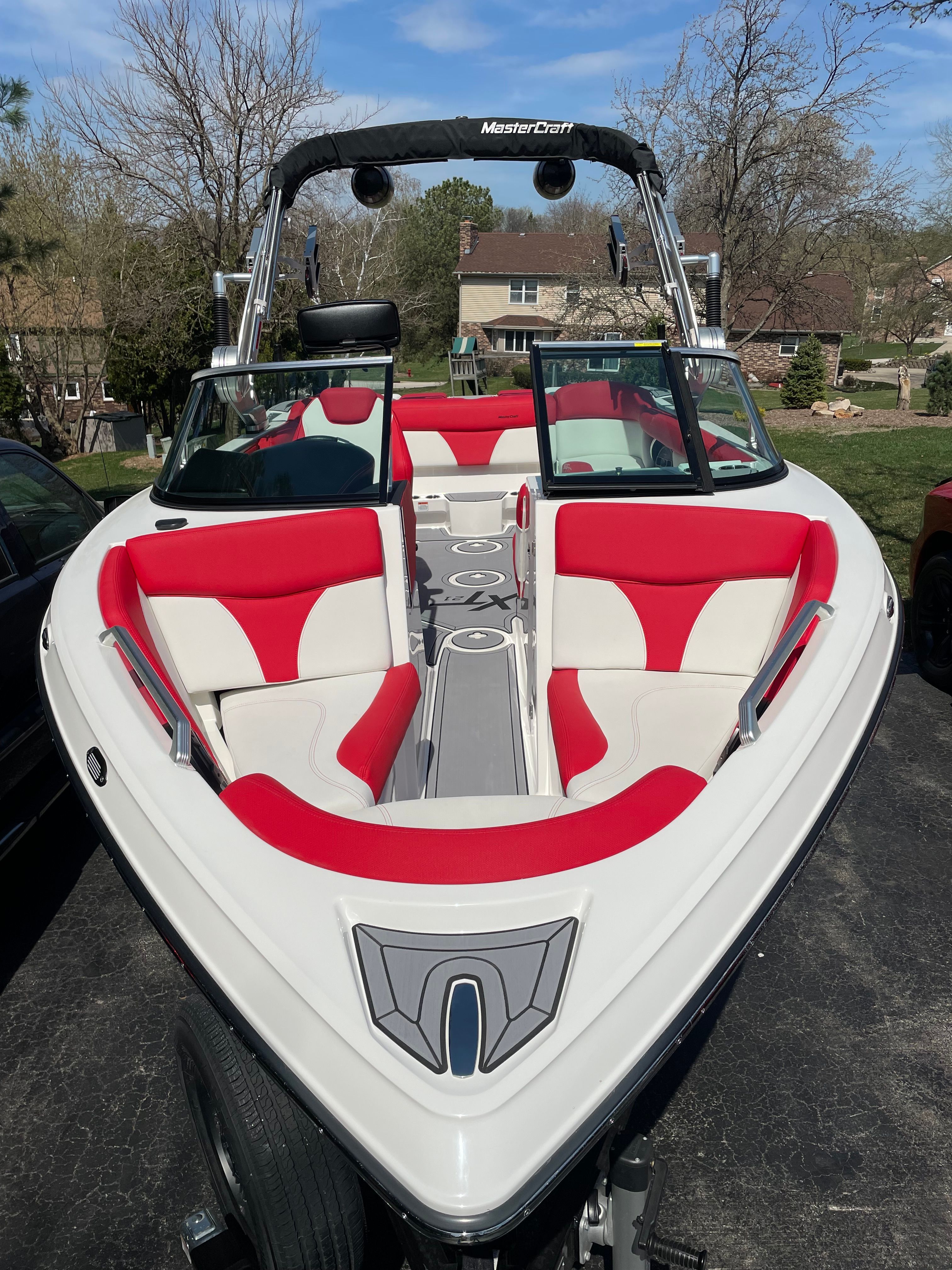 2019 Master XT21 boat with red and white seats, parked outdoors.