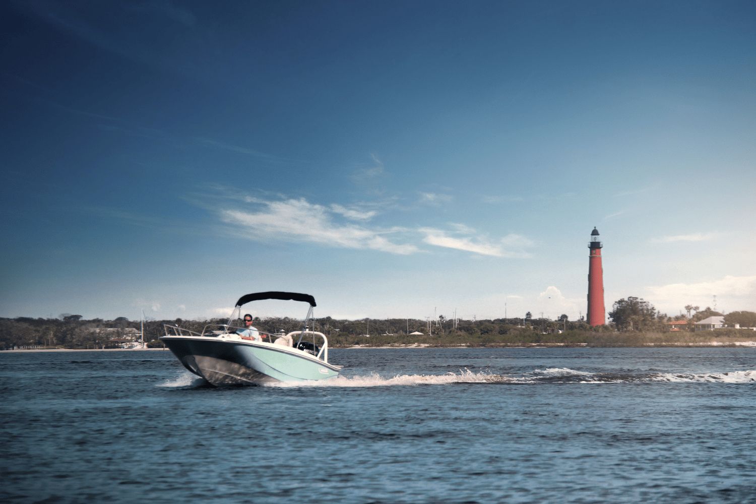 A 2026 Boston Whaler 160 Super Sport cruising on water near a lighthouse.