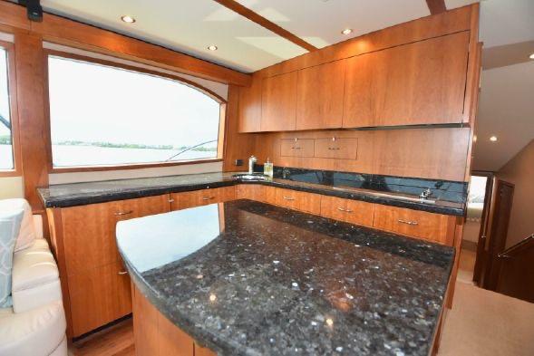 Luxurious interior of 2013 Hatteras GT54 yacht with sleek wooden cabinetry and granite countertops.