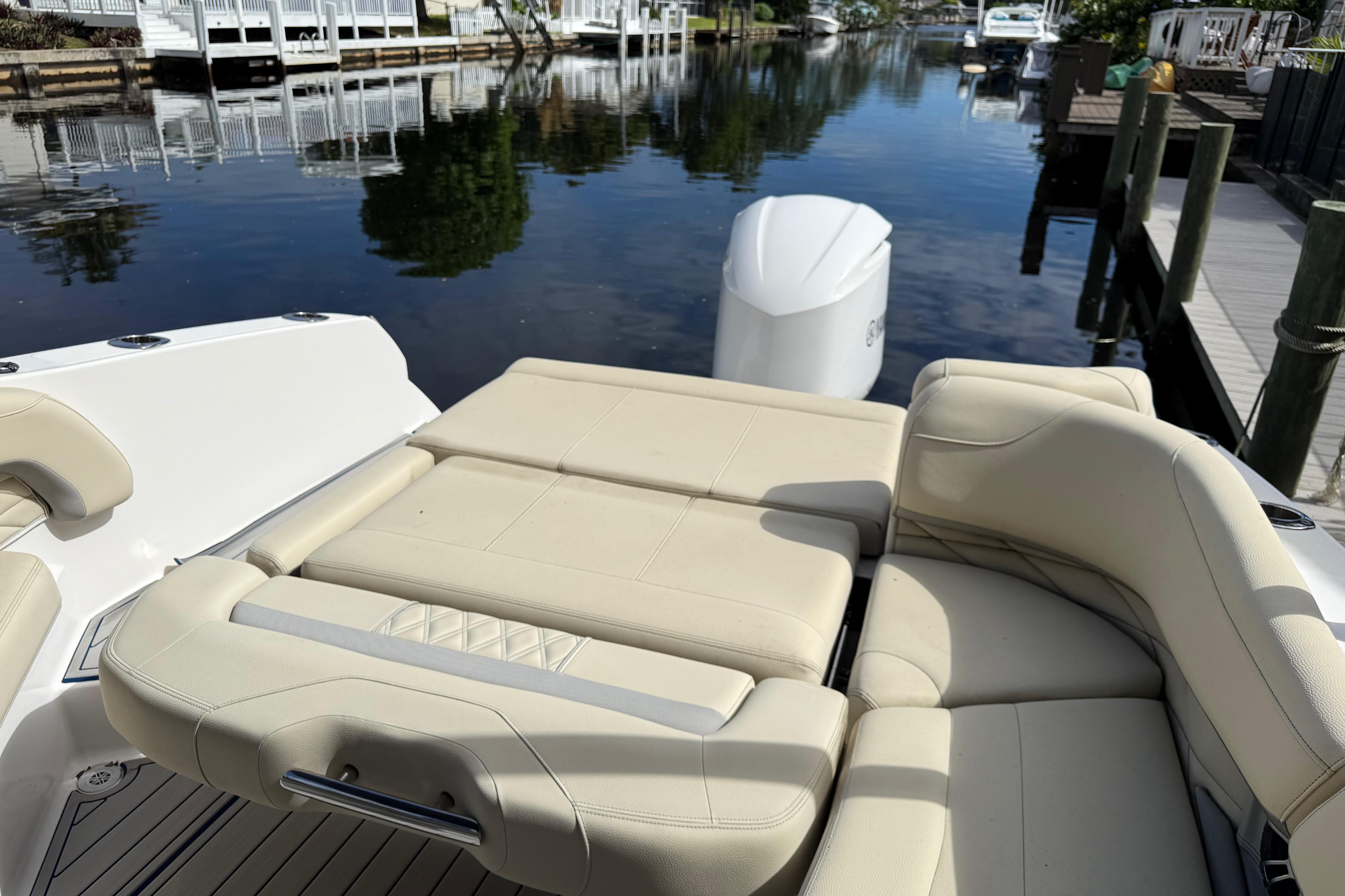 2021 Regal 26 OBX boat with beige seating, docked by a calm waterfront.