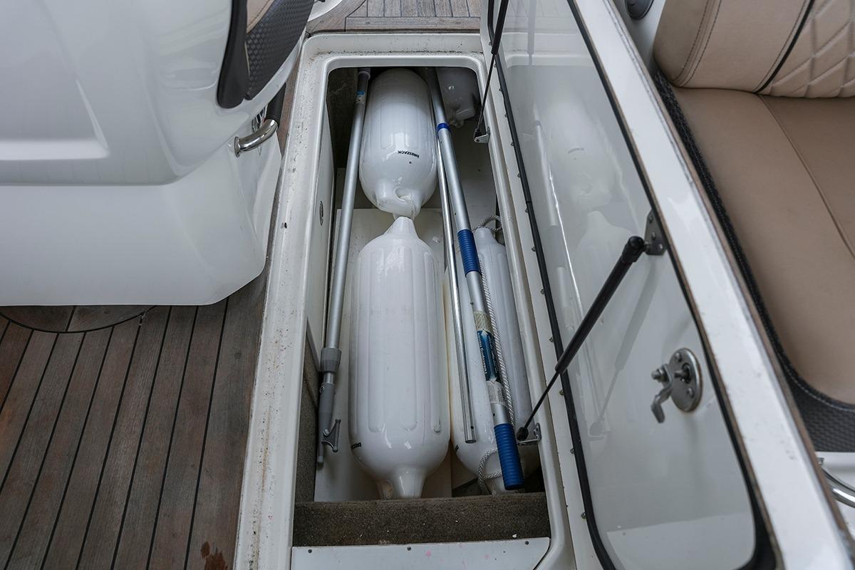 Storage compartment on 2018 Sea Ray SLX 350 boat with fenders and equipment.