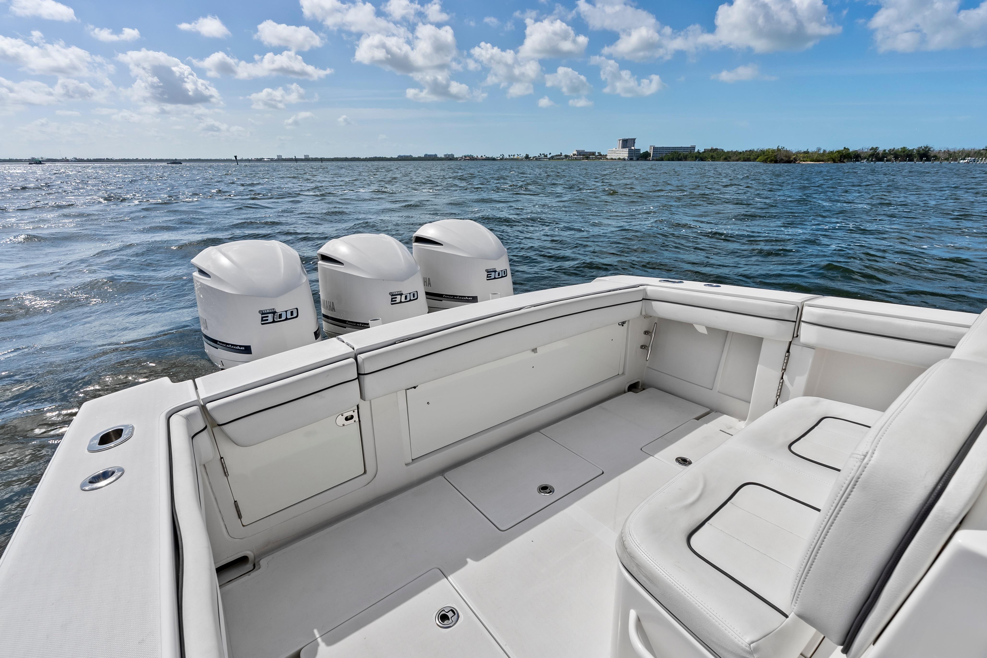 2015 Jupiter 34 HFS boat with triple 300 horsepower engines on open water.