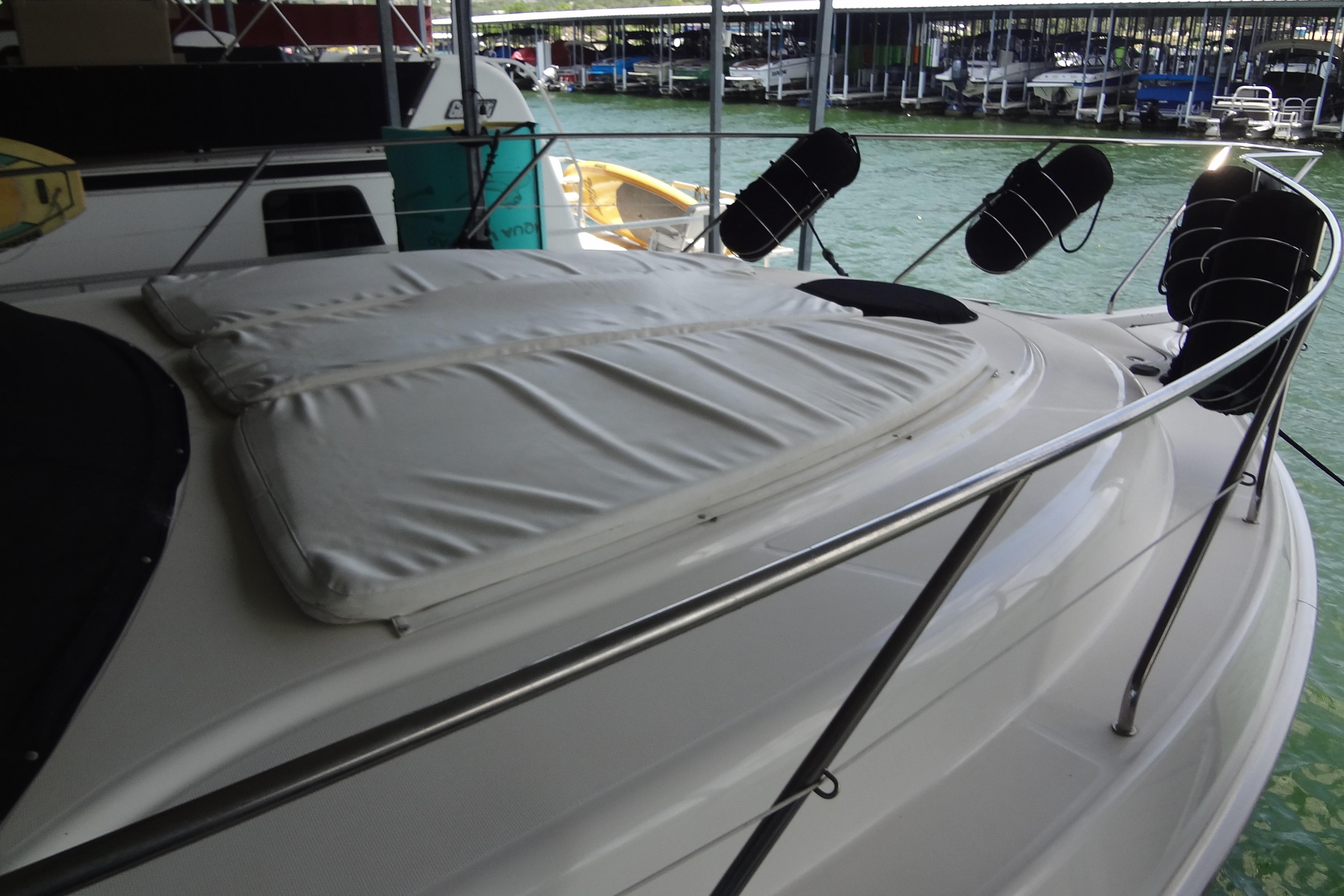 2005 Silverton 34 Convertible yacht with cushioned deck, docked at marina.