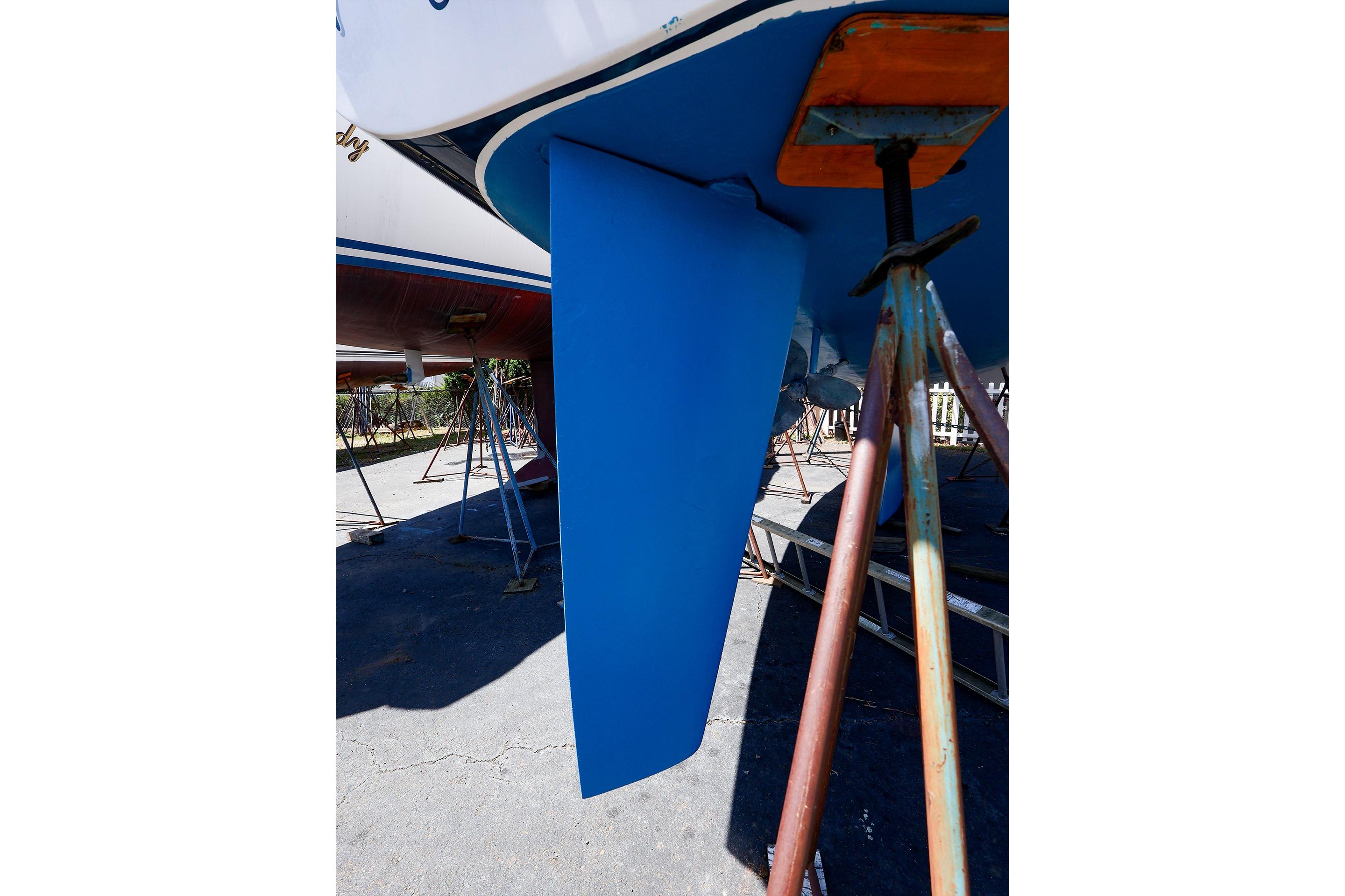 2001 J Boats J/32 sailboat keel on stands, blue hull, outdoor setting.