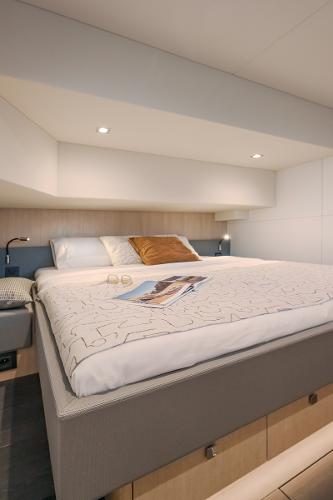 Luxurious bedroom in 2025 Privilege Signature 650 yacht, featuring modern design and cozy lighting.
