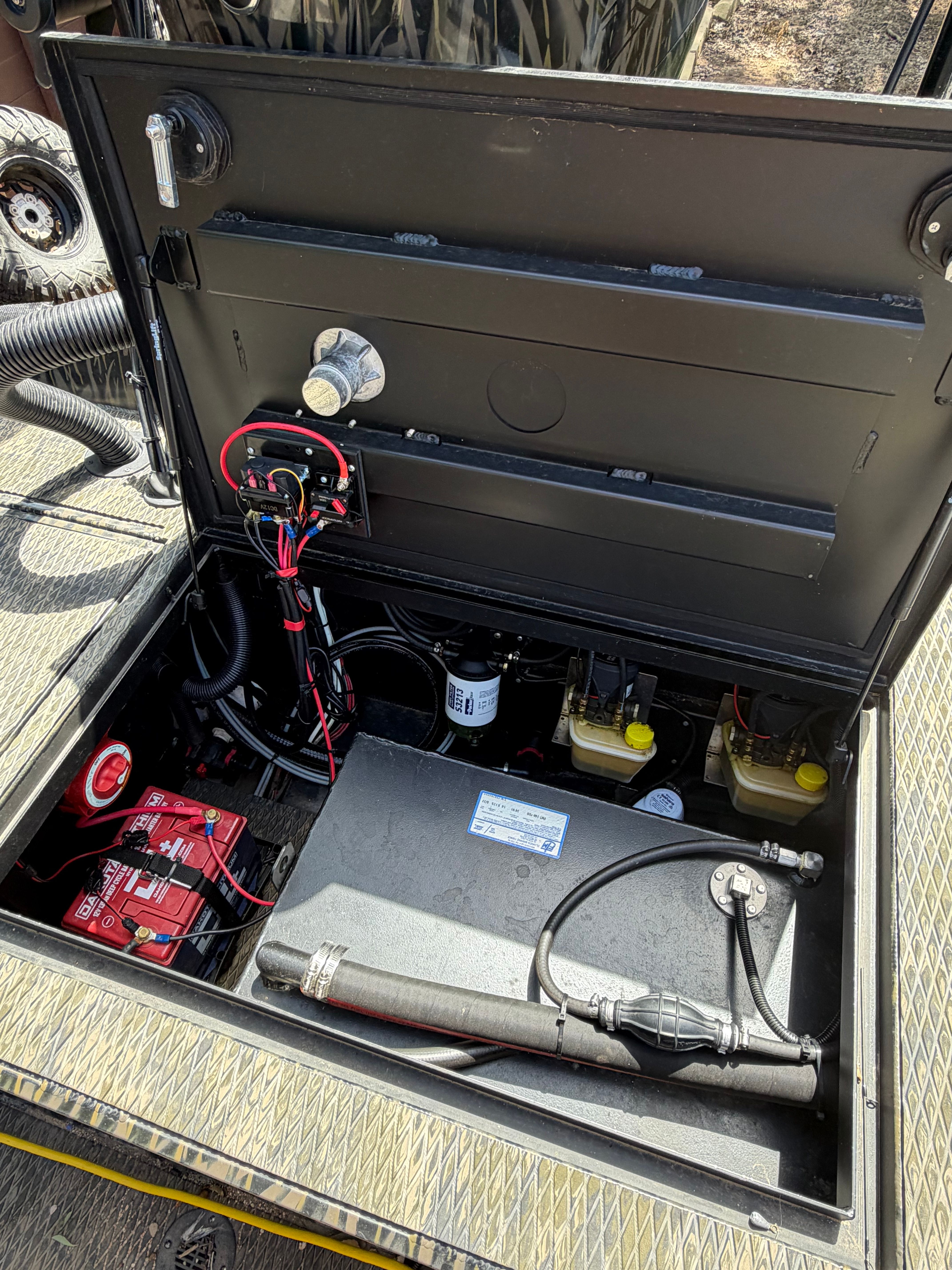 Battery compartment of a 2023 Prodigy 1860 boat with wiring and components.