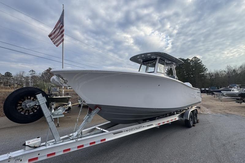 2026 Sportsman Open 282 Center Console boat on trailer under cloudy sky.
