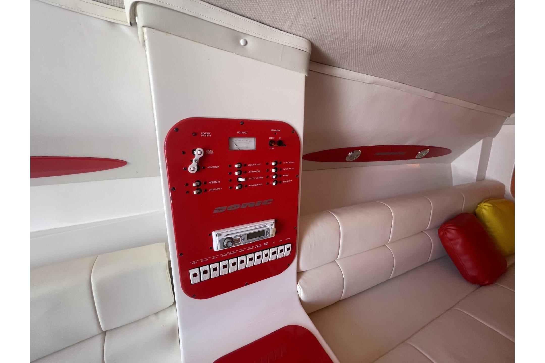 Interior of a 2006 Sonic 386 boat with red control panel and white seating.