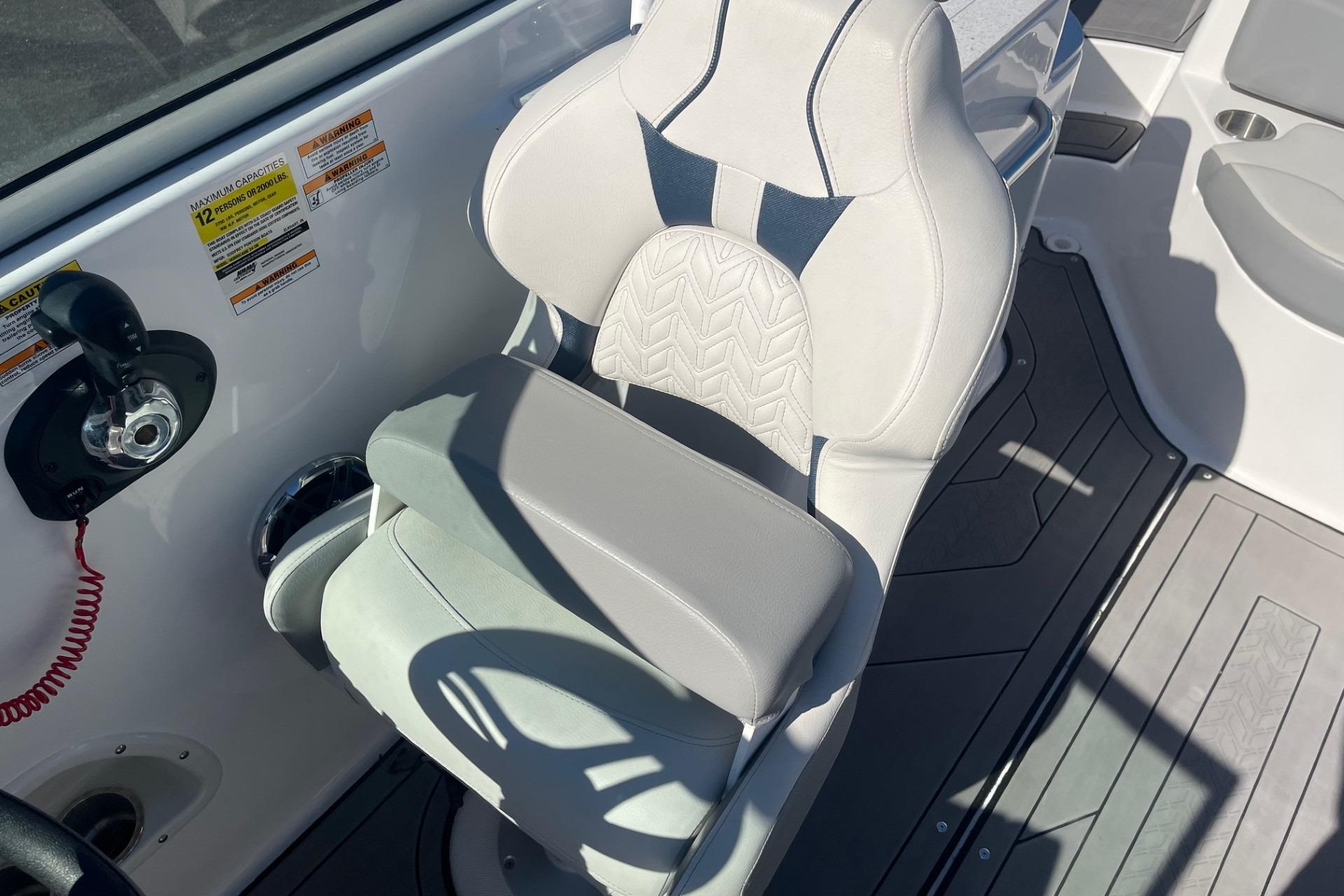 Captain's seat on 2023 Hurricane SunDeck 2400 OB boat, featuring ergonomic design and controls.
