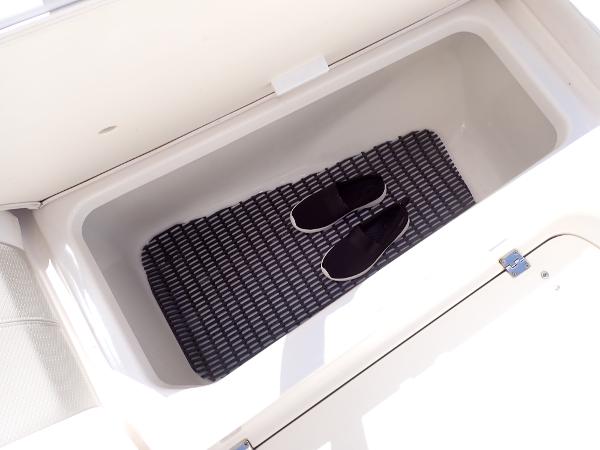 Storage compartment in 2011 Chaparral 287 SSX boat with mat and shoes inside.