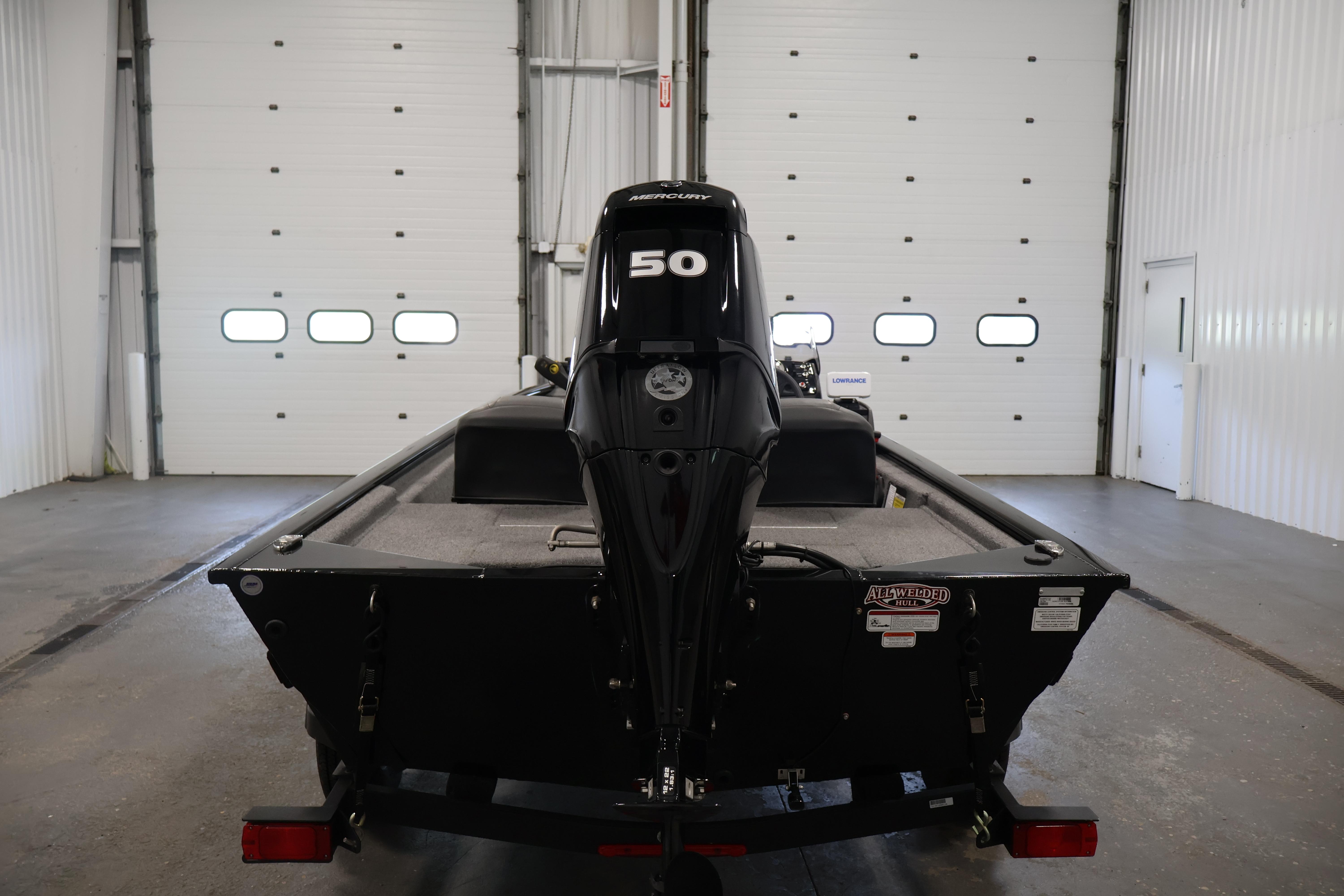 2024 Tracker Pro 170 boat in garage, rear view with 50 HP Mercury engine.
