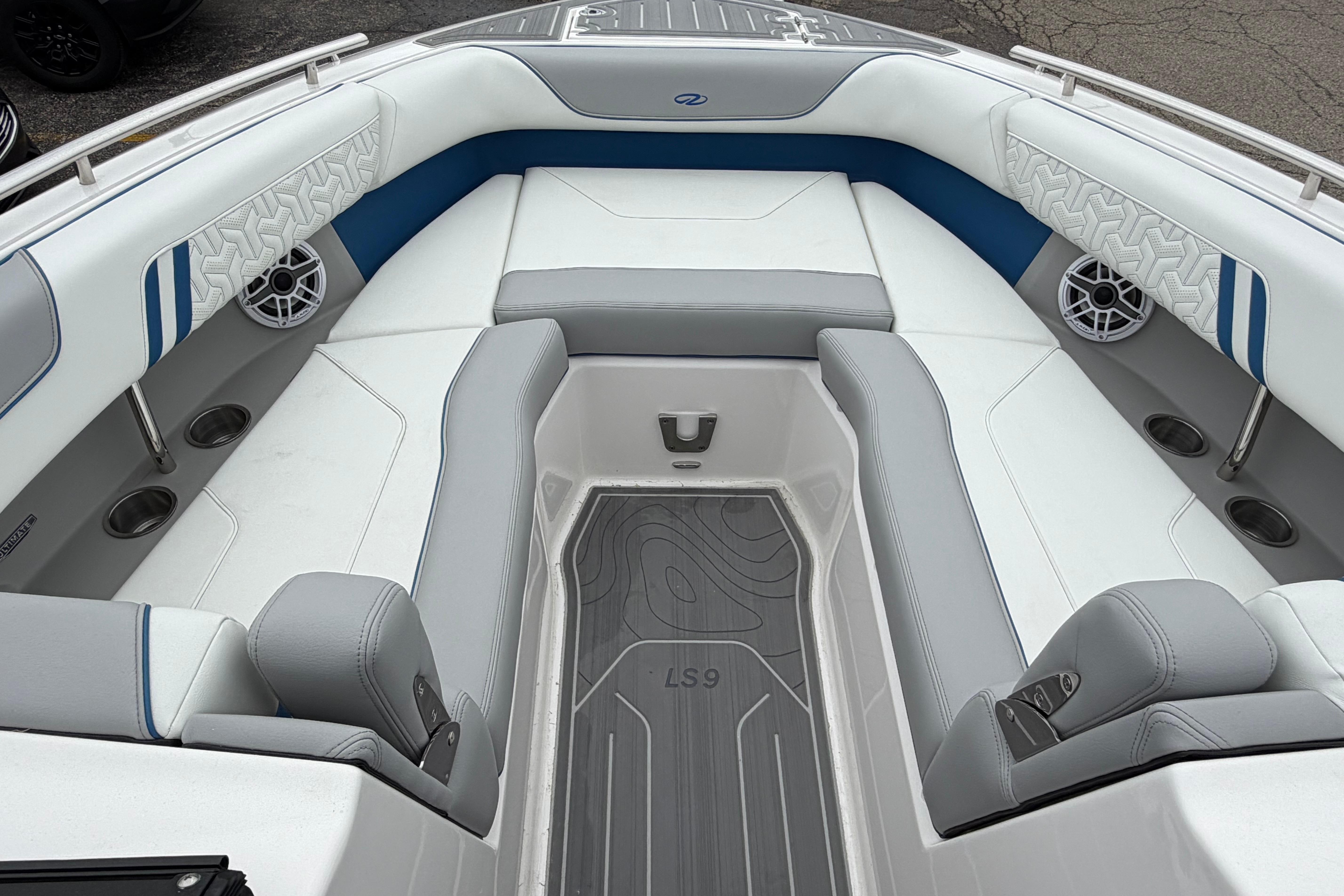 2026 Regal LS9 Surf boat interior with gray and blue seating, cup holders, and speakers.