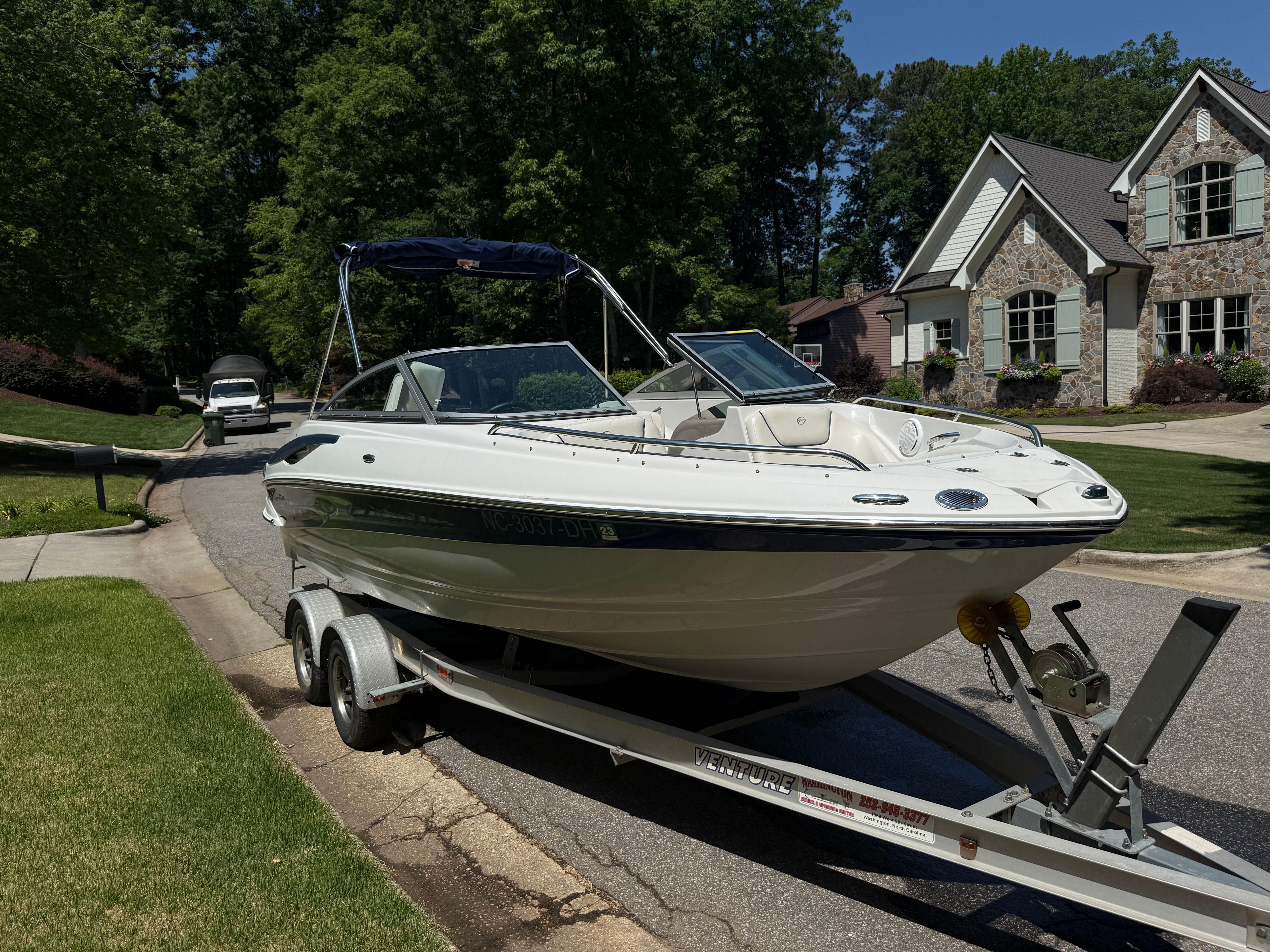 2008 Crownline 210 LX boat on trailer in residential area.