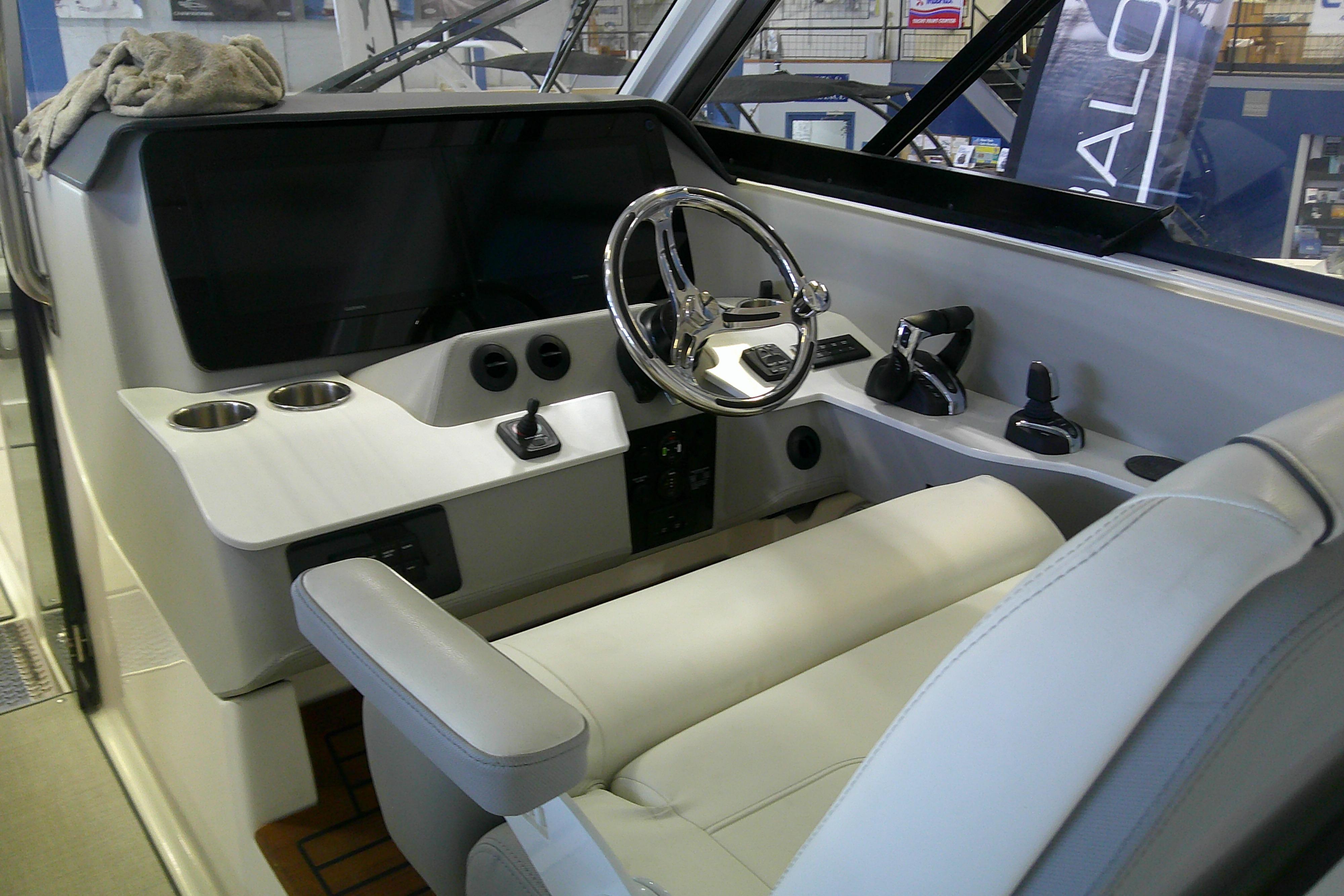 2023 Regal LX36 boat cockpit with steering wheel, controls, and comfortable seating.