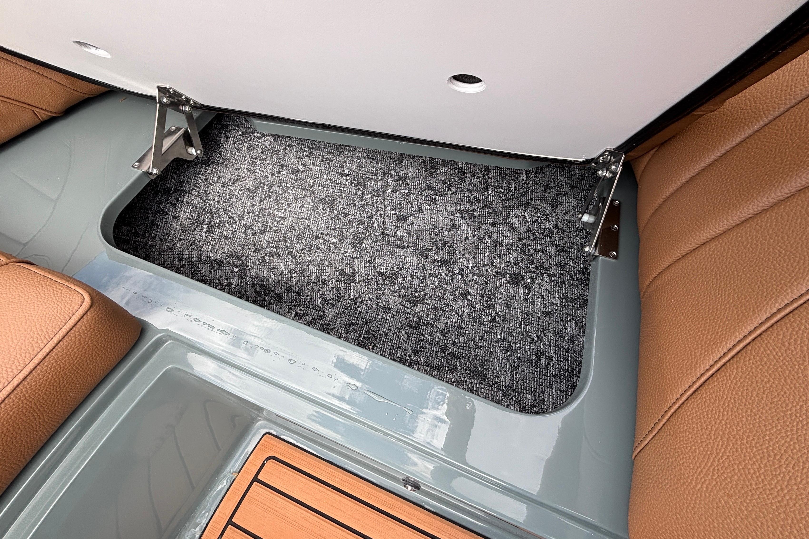 Interior storage compartment of 2026 MB B52 23 Classic boat with brown seating.